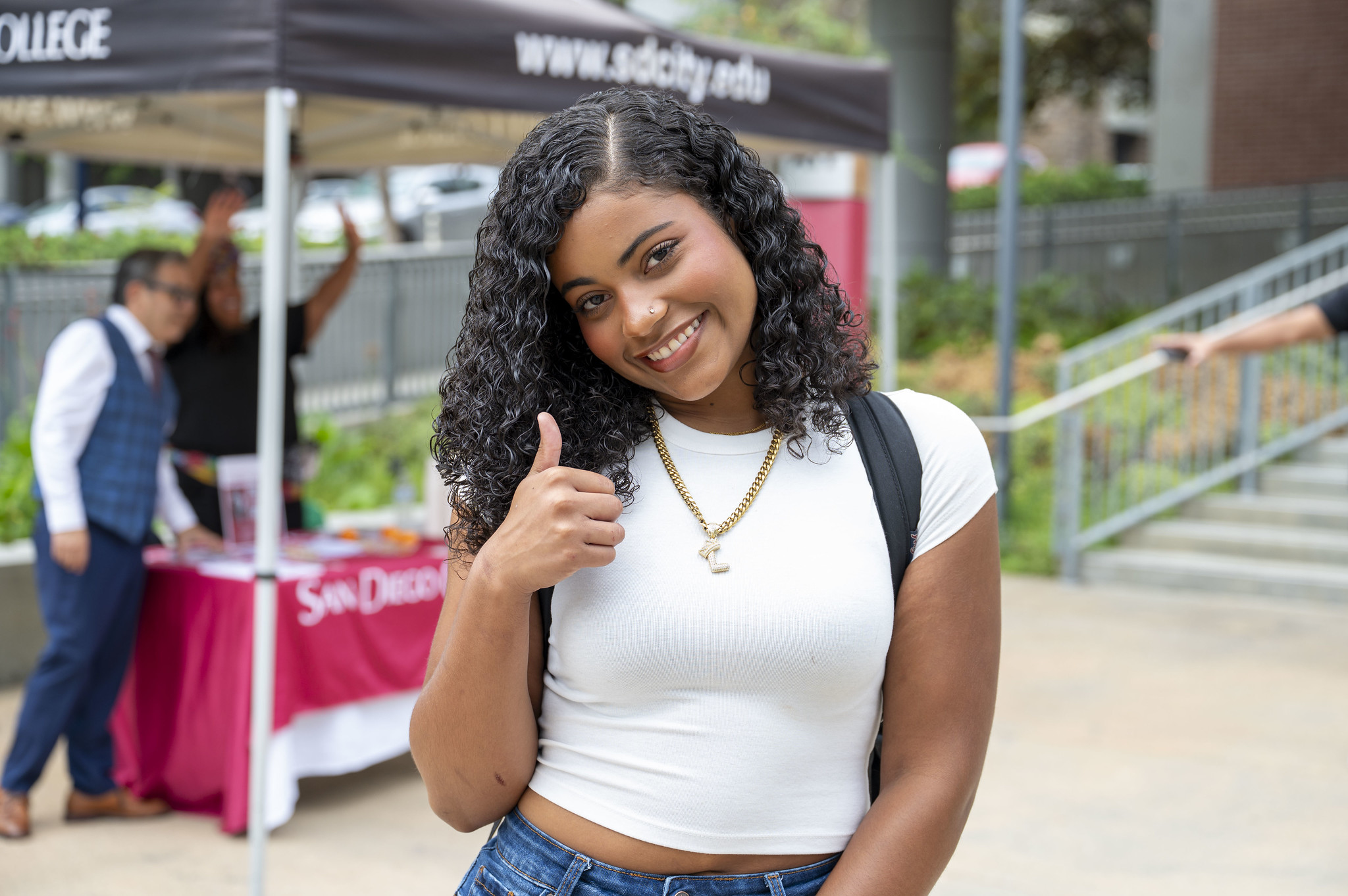 
A student near a welcome tent gives a thumbs up.

