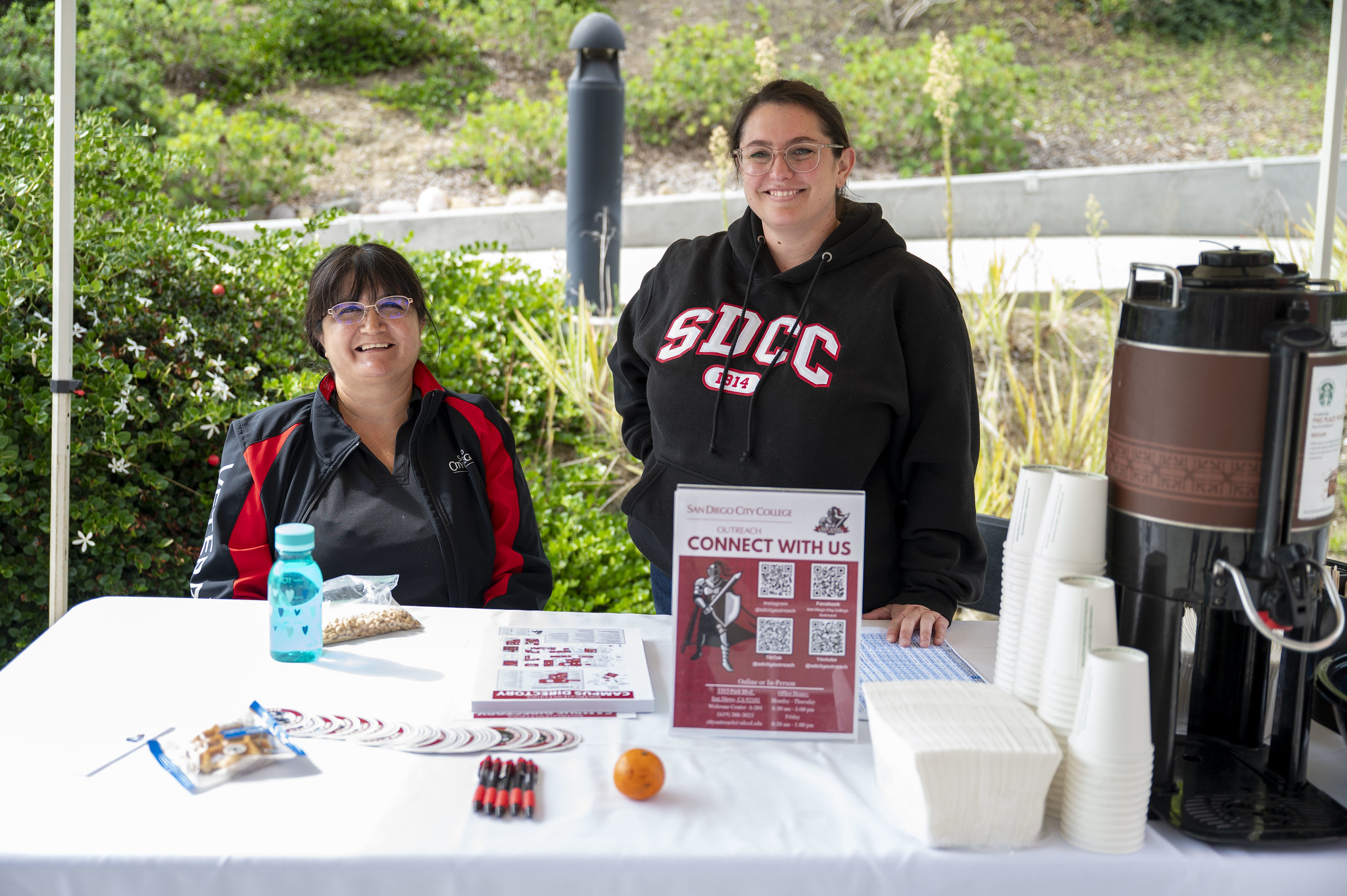 
Two people working at a welcome tent.
