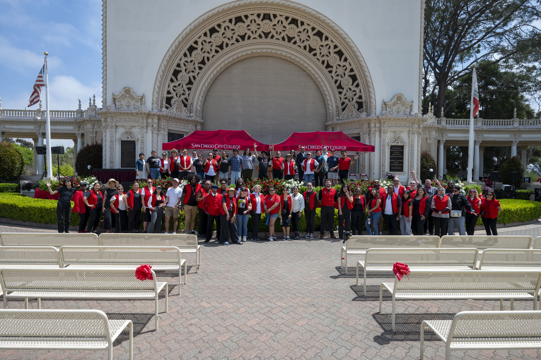 
Dozens of volunteers in red shirts gather for a group photo in front of the stage before everyone arrives.
