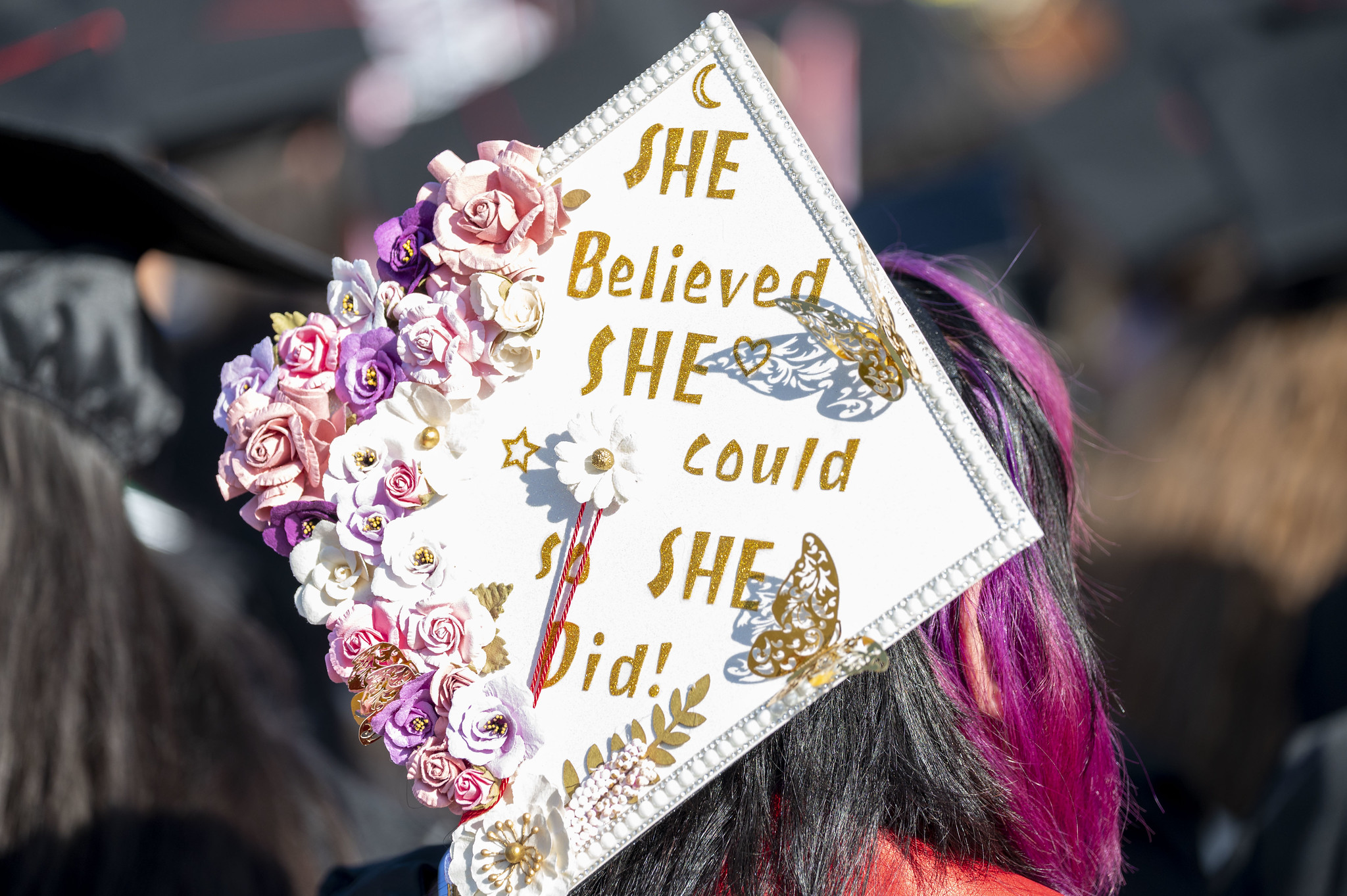 
A white decorated graduation cap that says She Believed She Could So She Did!
