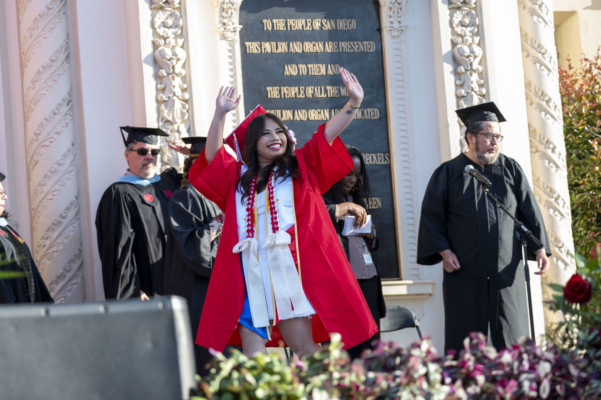 
A graduate cheers on stageas her name is read.
