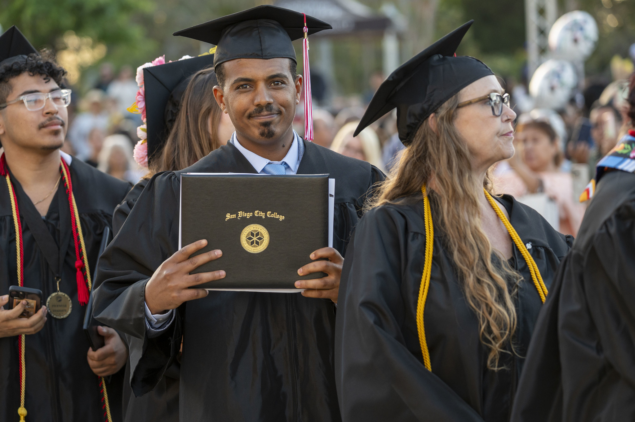 
A graduate holds up his diploma.
