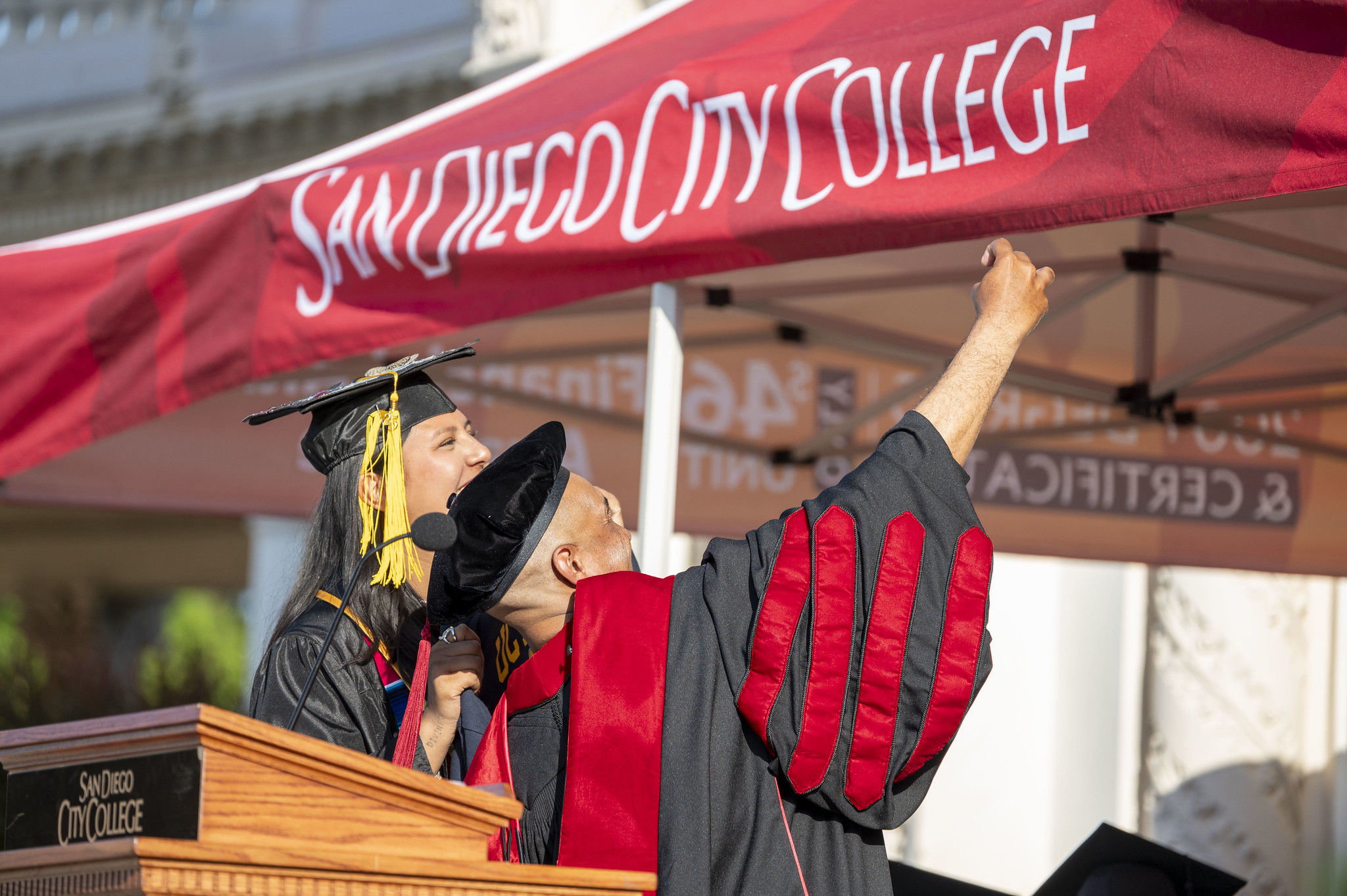 
City College President Ricky Shabazz takes a selfie with Associated Students President Daliah Ramirez at the podium on stage during commencement.
