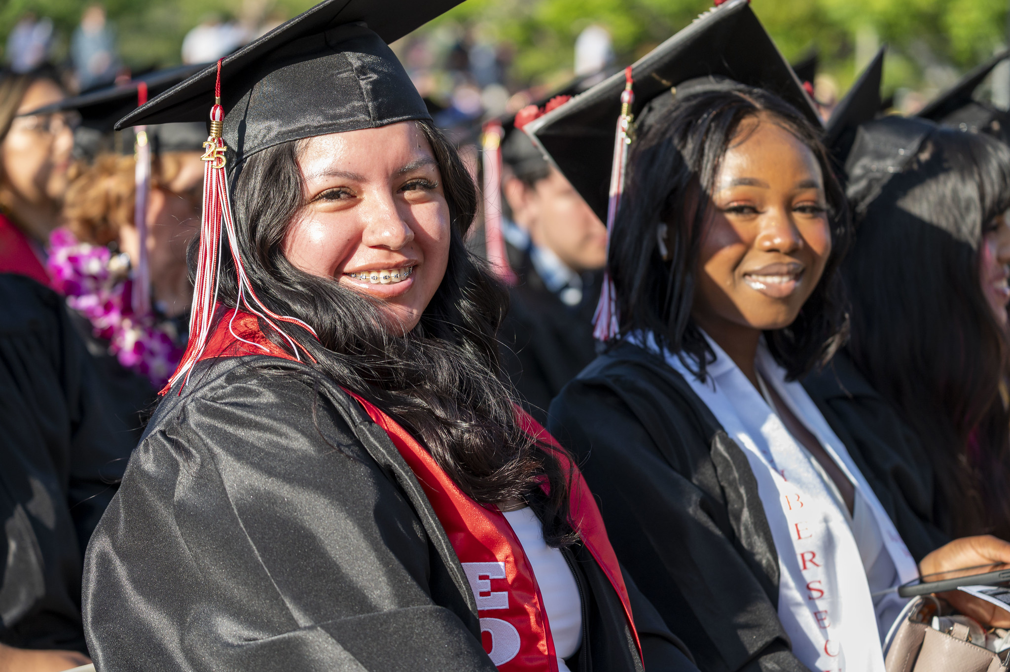 
Two graduates seated at commencement.

