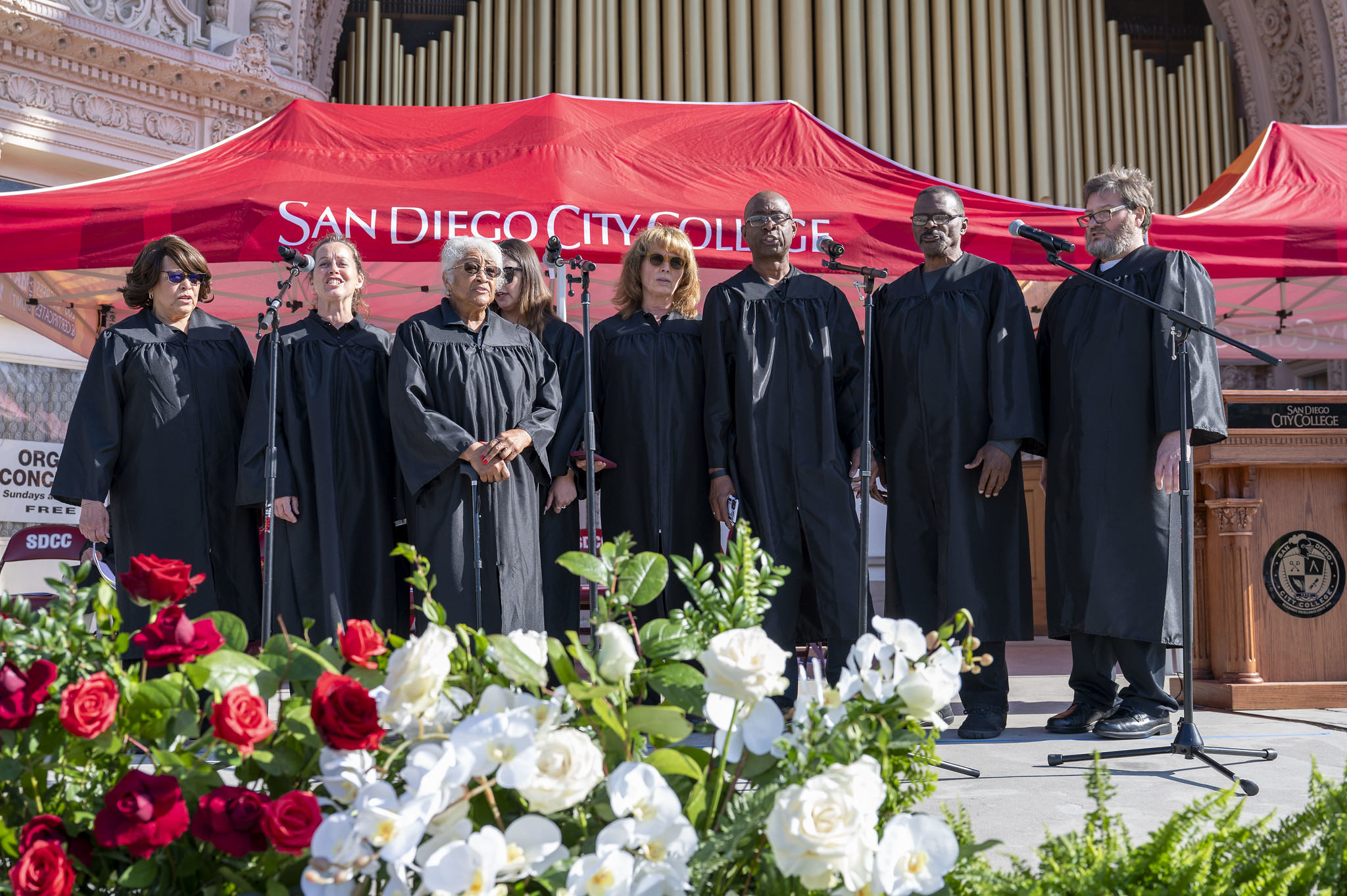 
Eight singers in black robes on stage.
