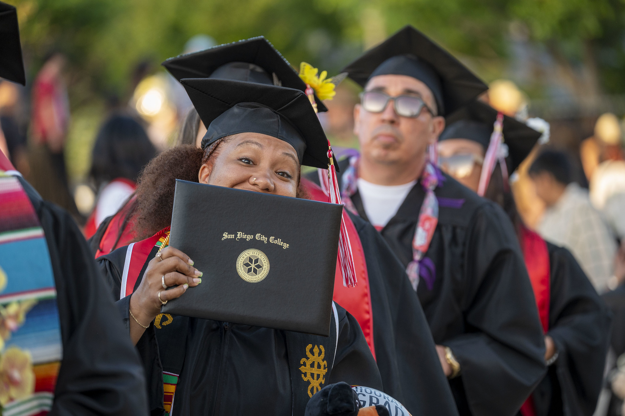 
A graduate holds up her degree.

