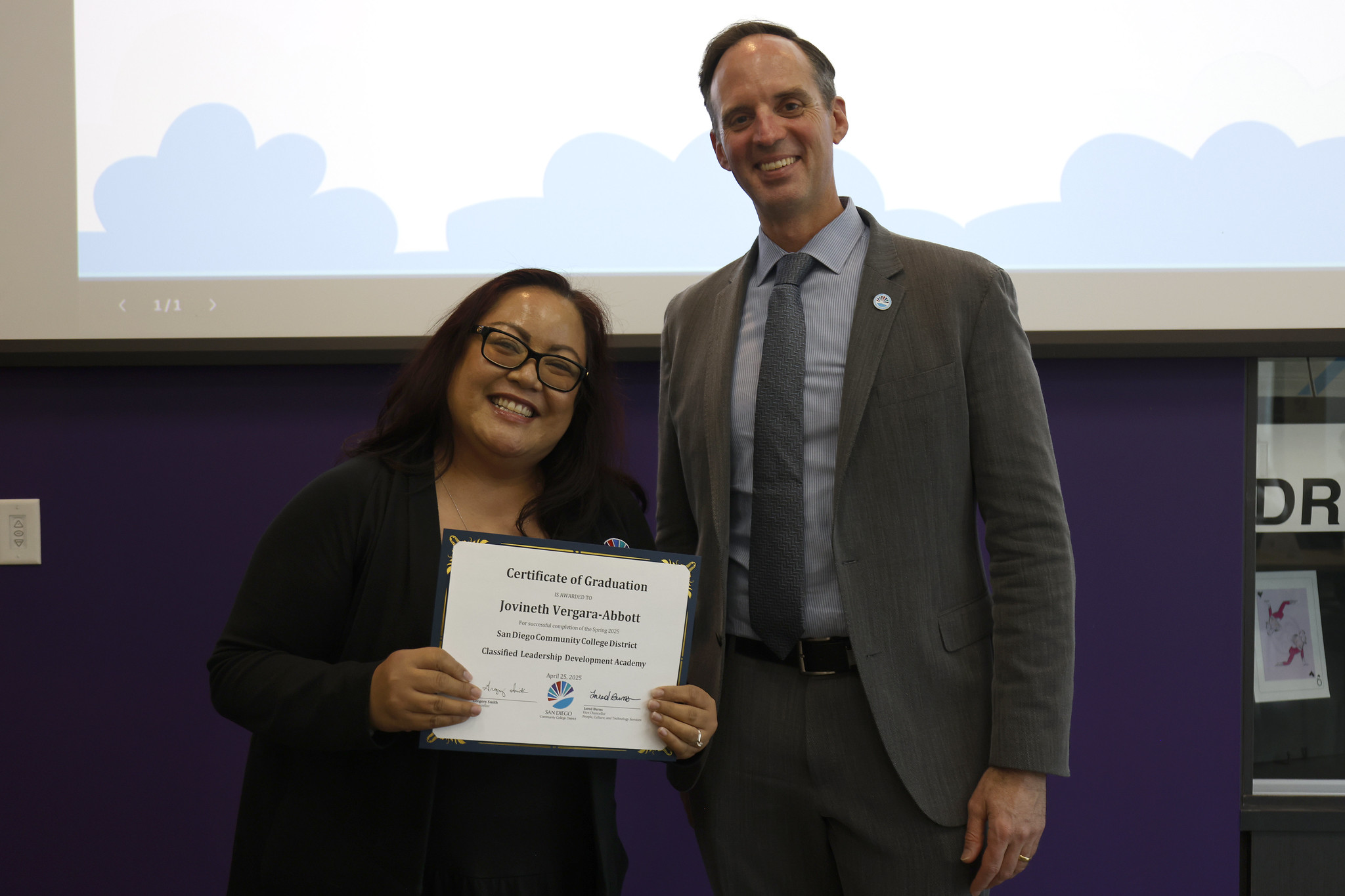 
Jovi Vergara-Abbott holds up her certificate with the chancellor
