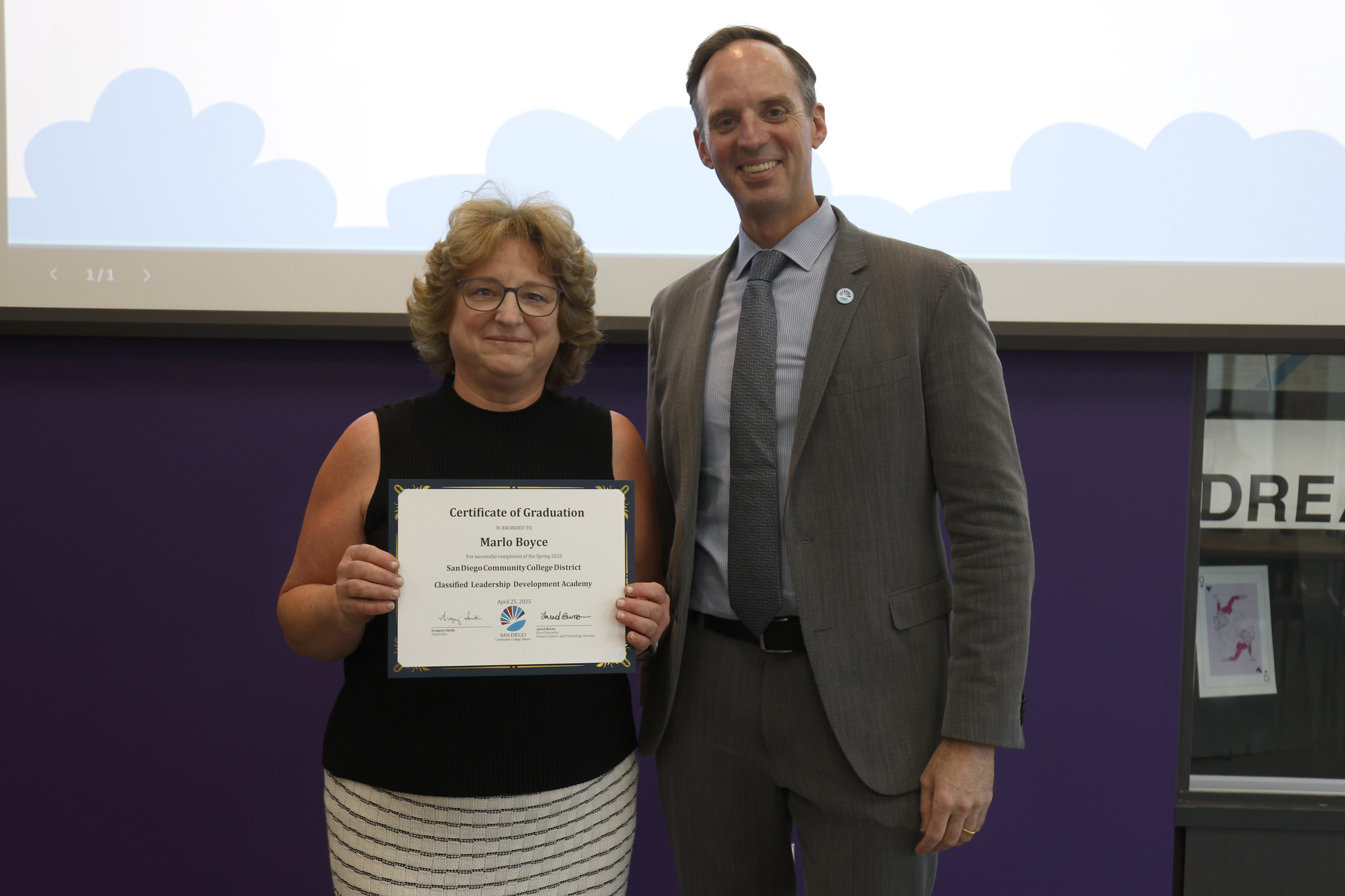 
Marlo Boyce holds up her certificate with the chancellor.
