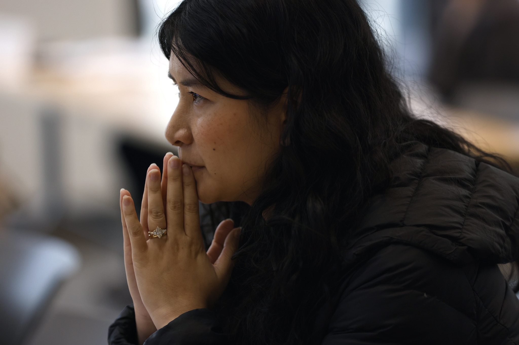 
A woman in the audience listening to a speaker.
