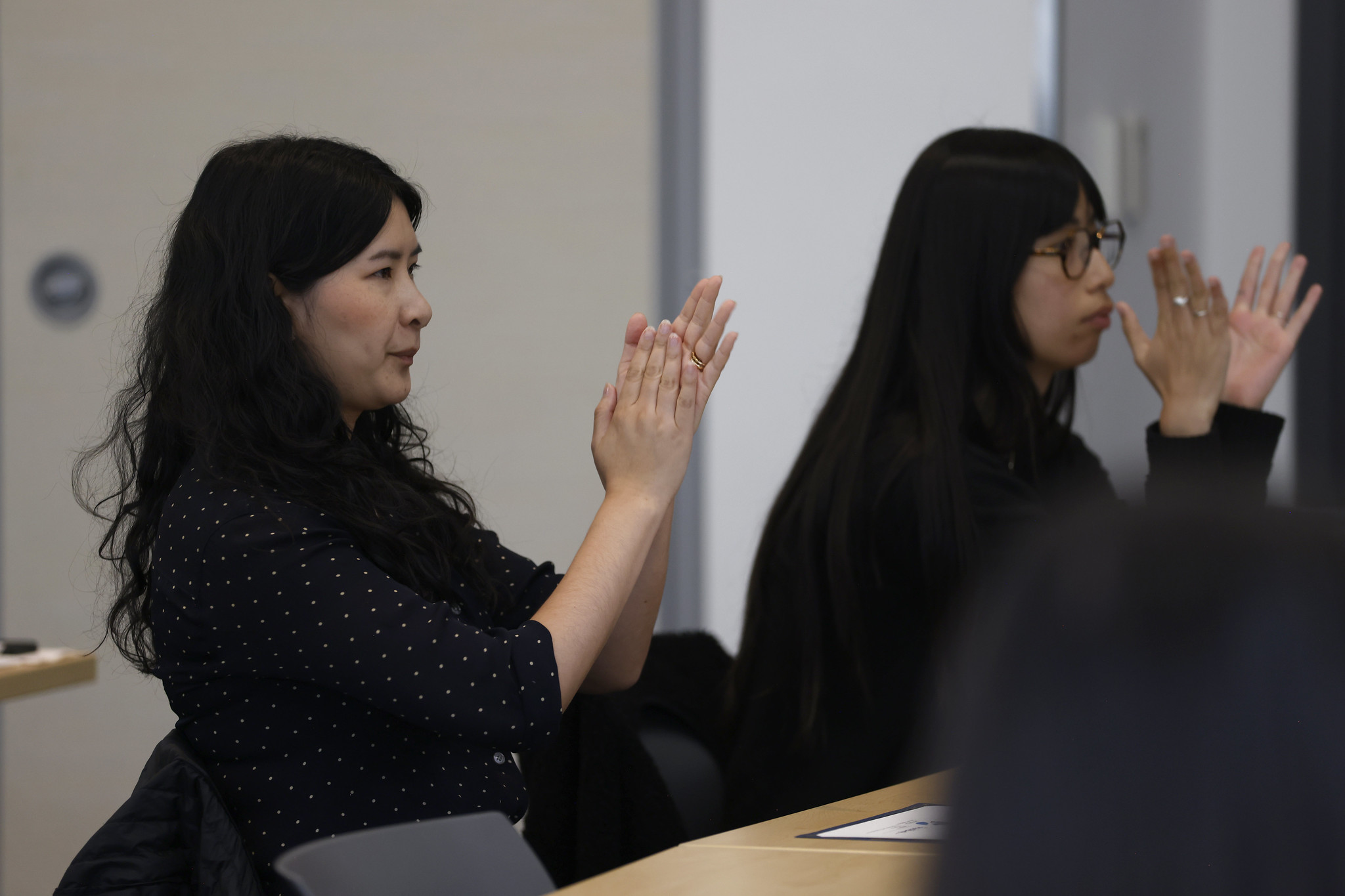 
Two women applauding at the event.
