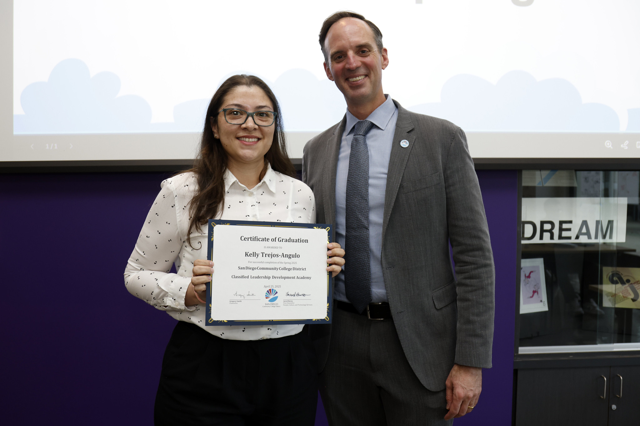 
Kelly Trejos-Angulo holds up her certificate with the chancellor.
