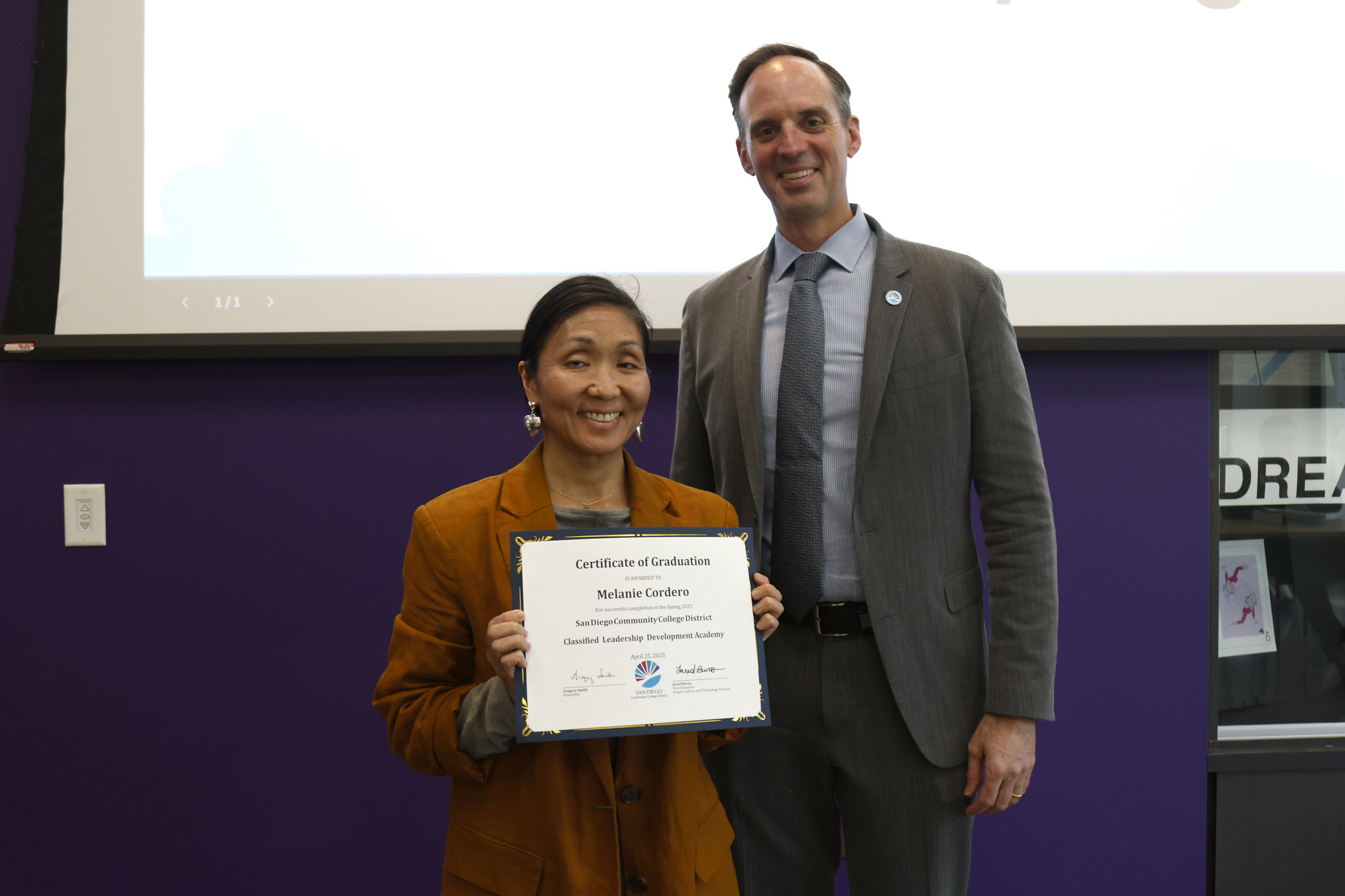 
Melanie Cordero holds up her certificate with the chancellor.
