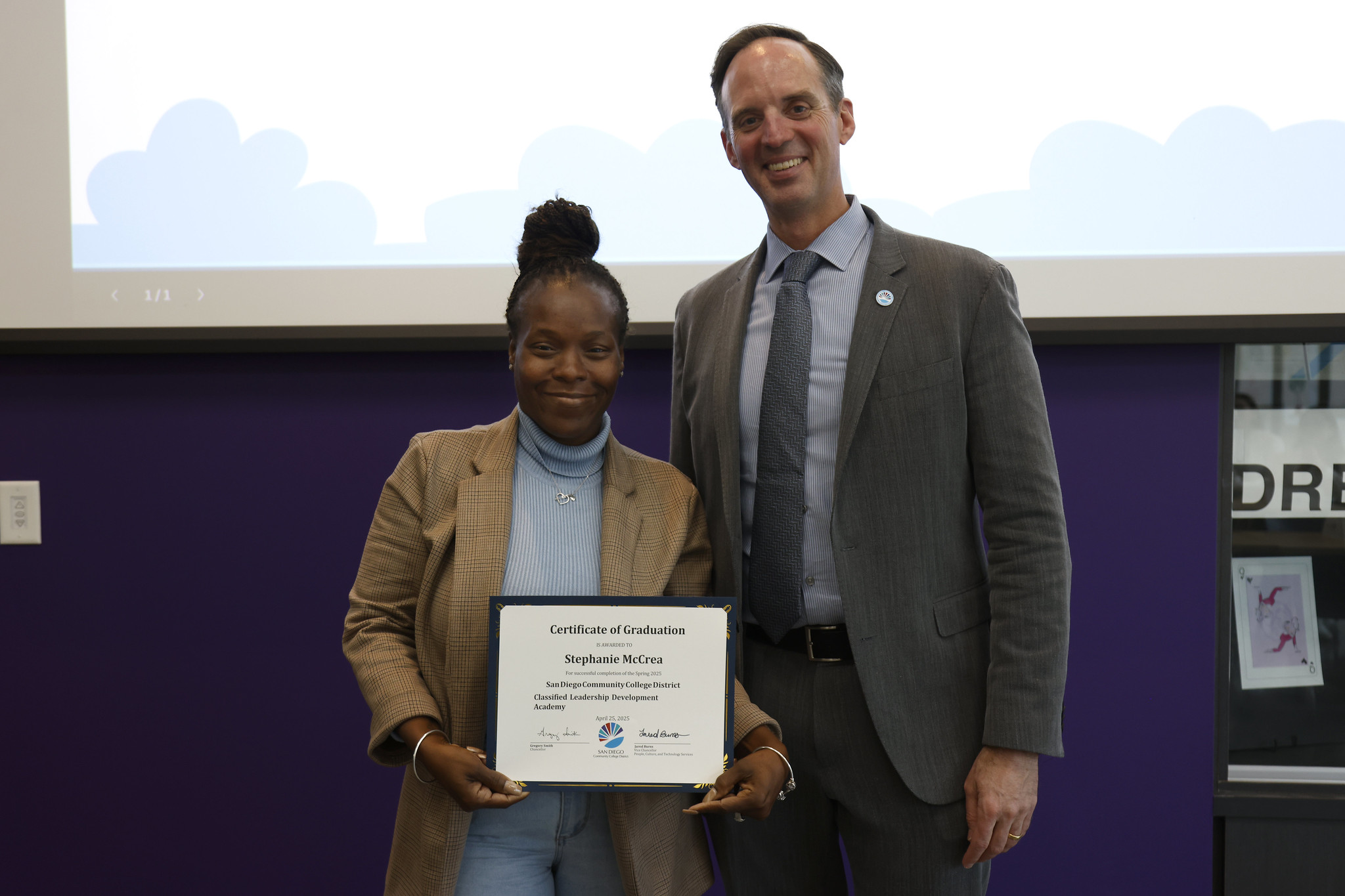 
Stephanie McCrea holds up her certificate with the chancellor.
