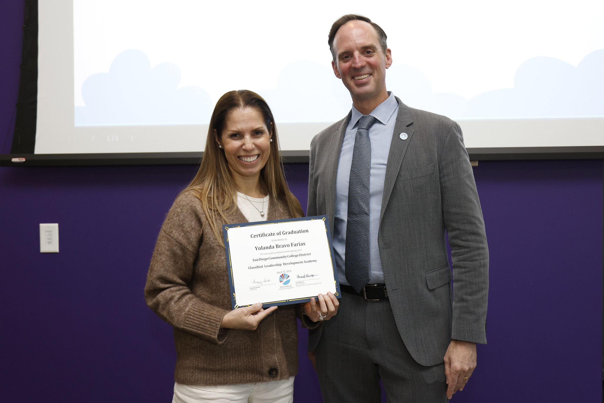 
Yolanda Bravo Farias holds her certificate with the chancellor.

