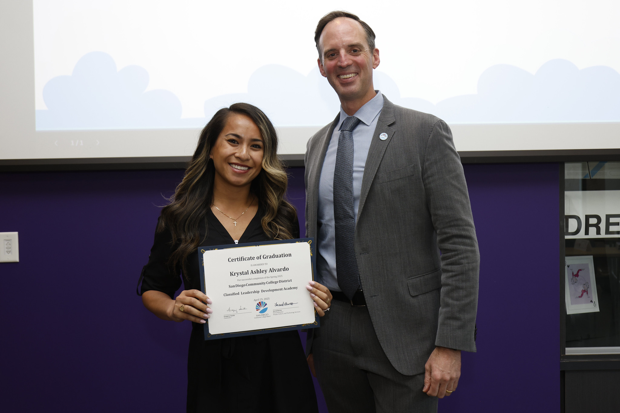
Krystal Alvardo holds up her certificate with the chancellor.
