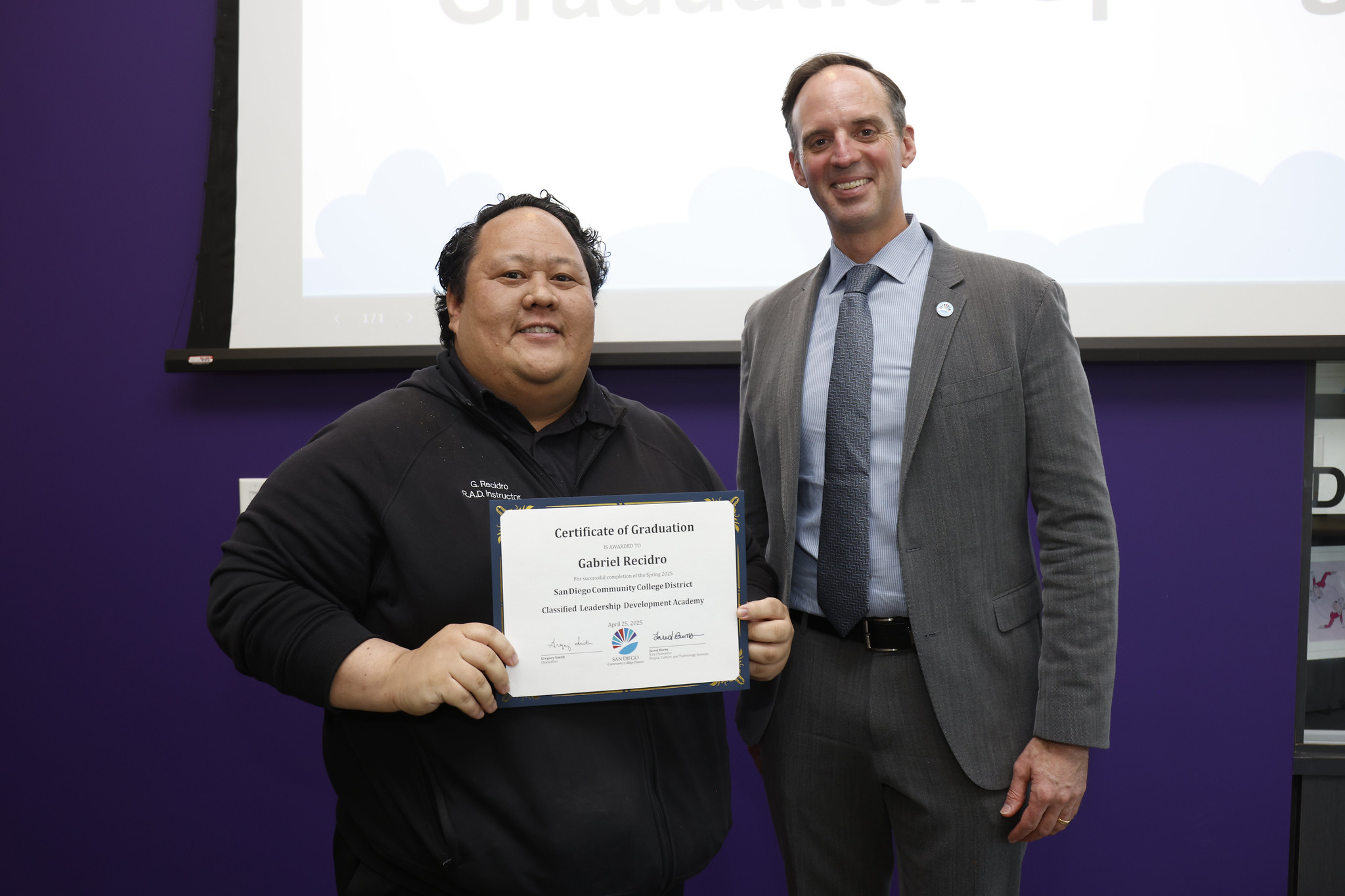 
Gabriel Recidro holds up his certificate with the chancellor.

