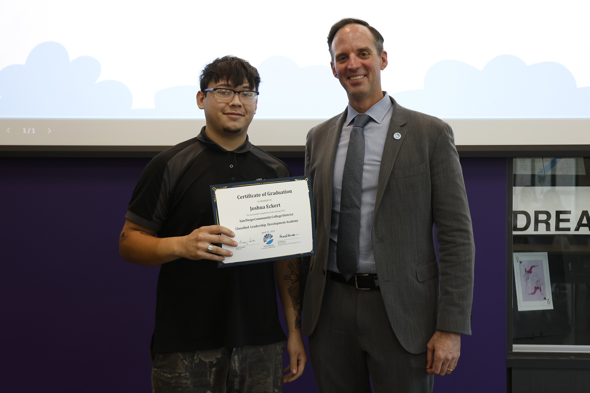 
Joshua Eckert holds up his certificate with the chancellor.
