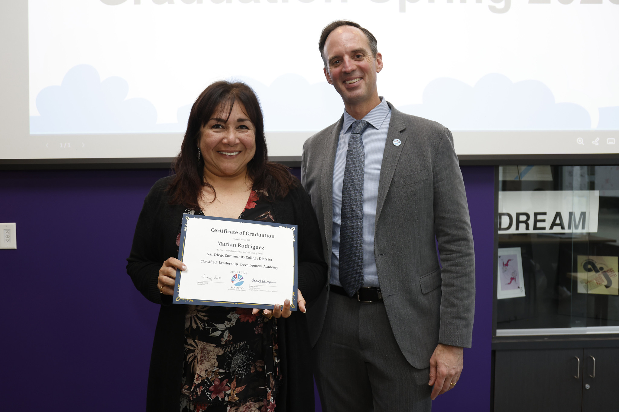 
Marian Rodriguez holds her certificate with the chancellor.
