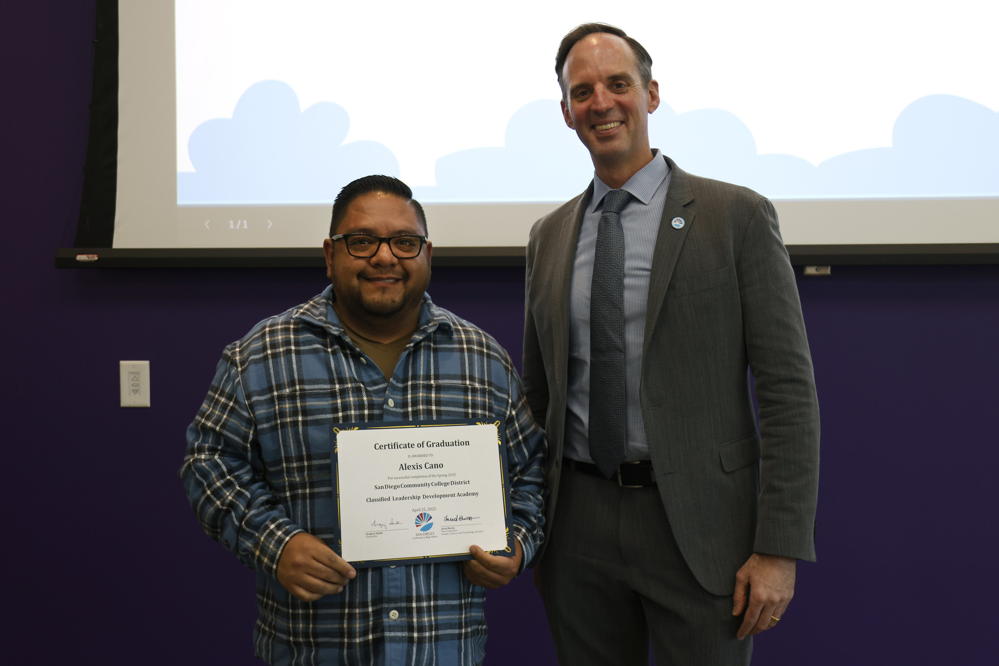 
Alexis Cano holds his certificate with the chancellor.
