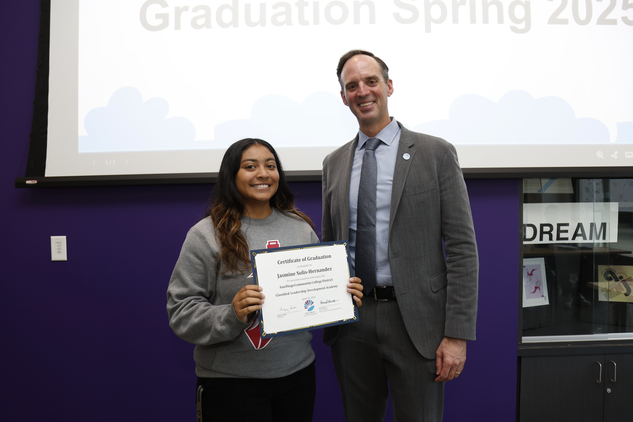 
Jasmine Solis-Hernandez holds her certificate with the chancellor.
