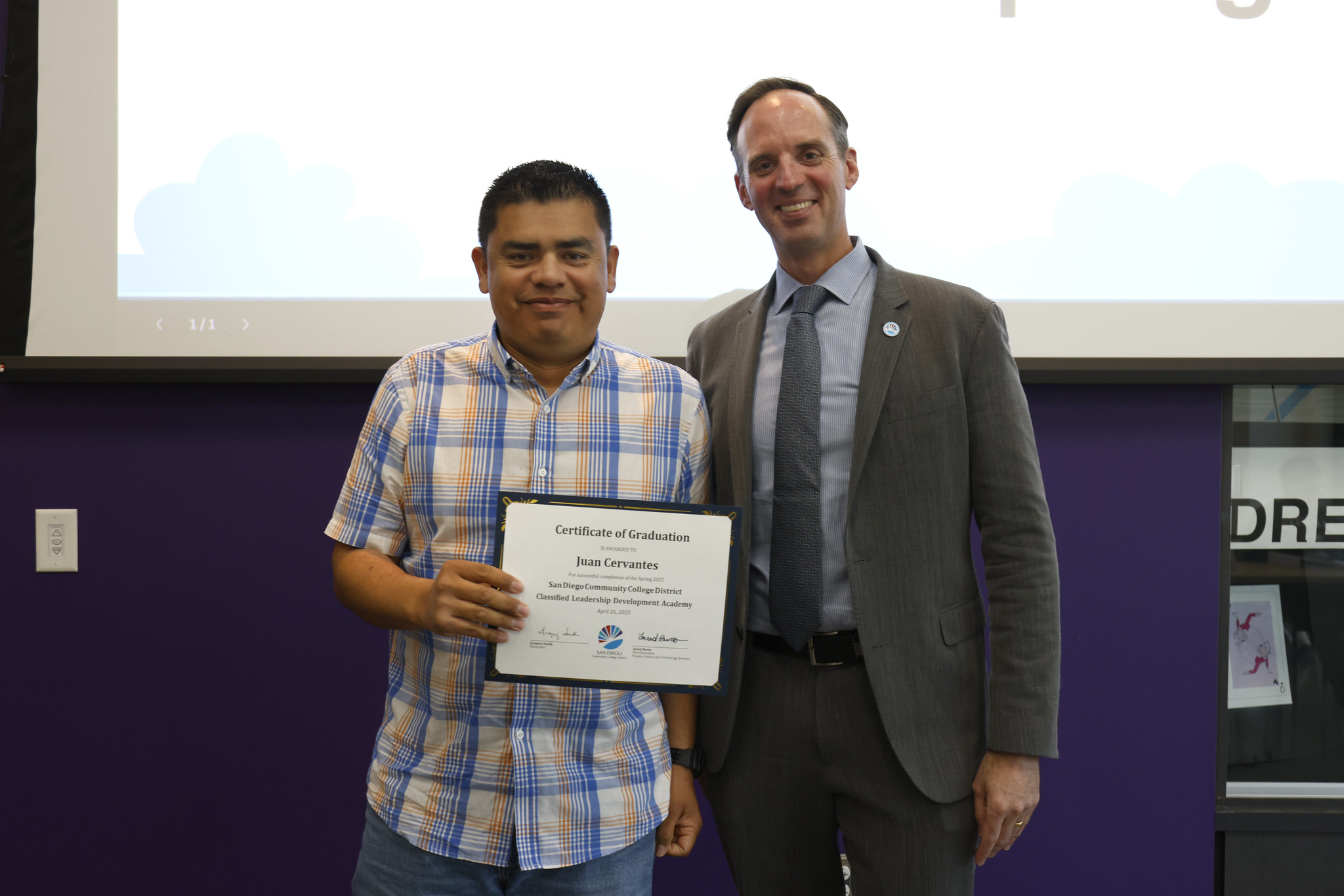 
Juan Cervantes holds his certificate with the chancellor.
