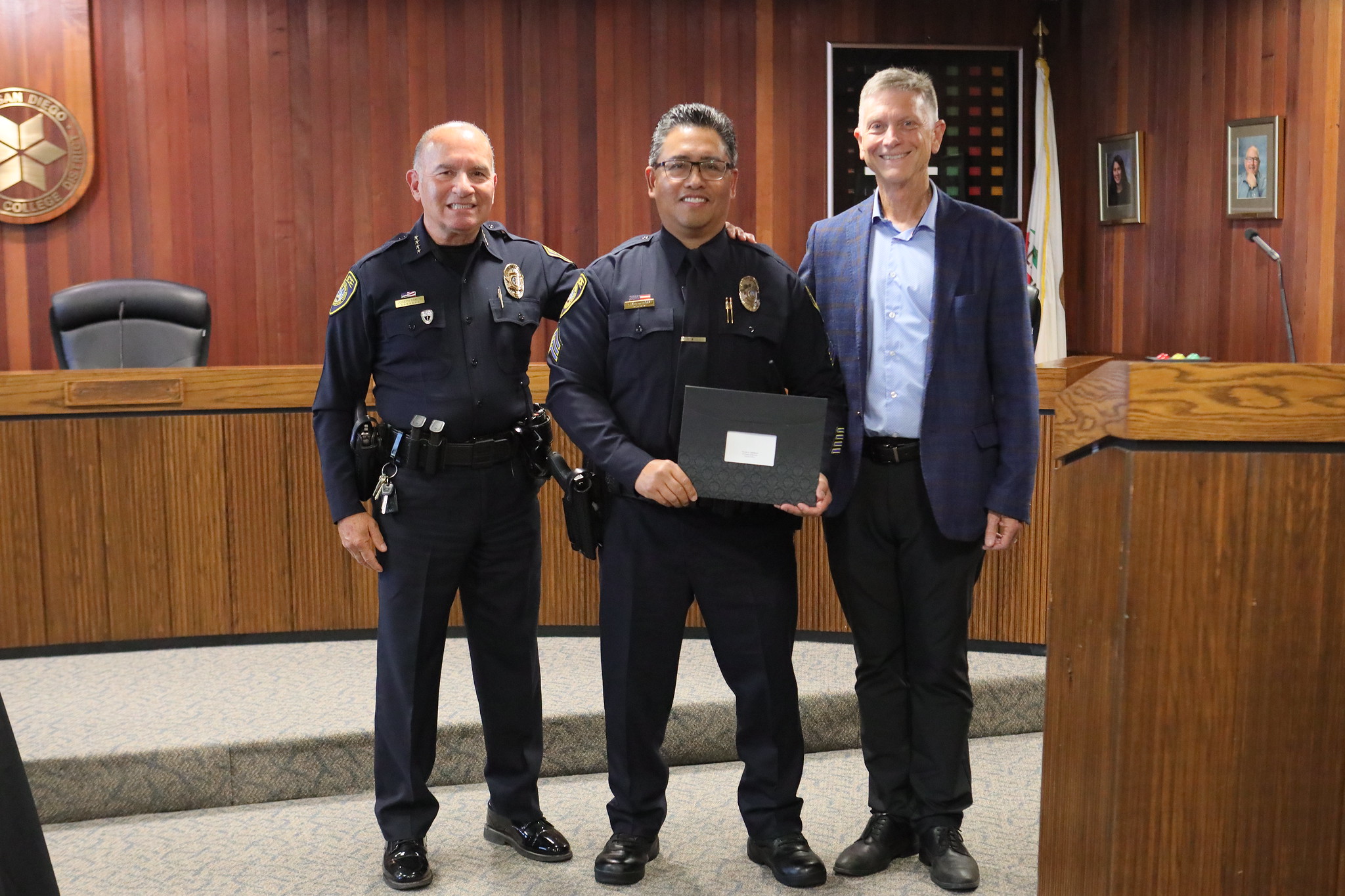 
A college police officer receives a service award with Chief Ramos and Lance Lareau.
