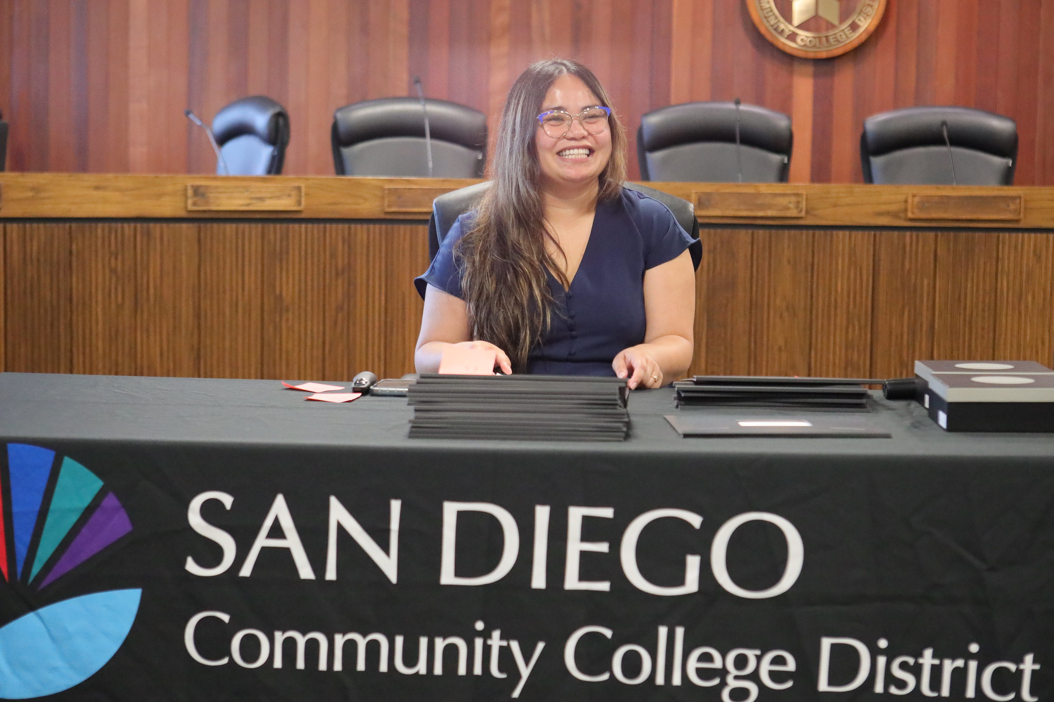 
Jhelen Ramirez sits at a table with the certificates that will be handed out.
