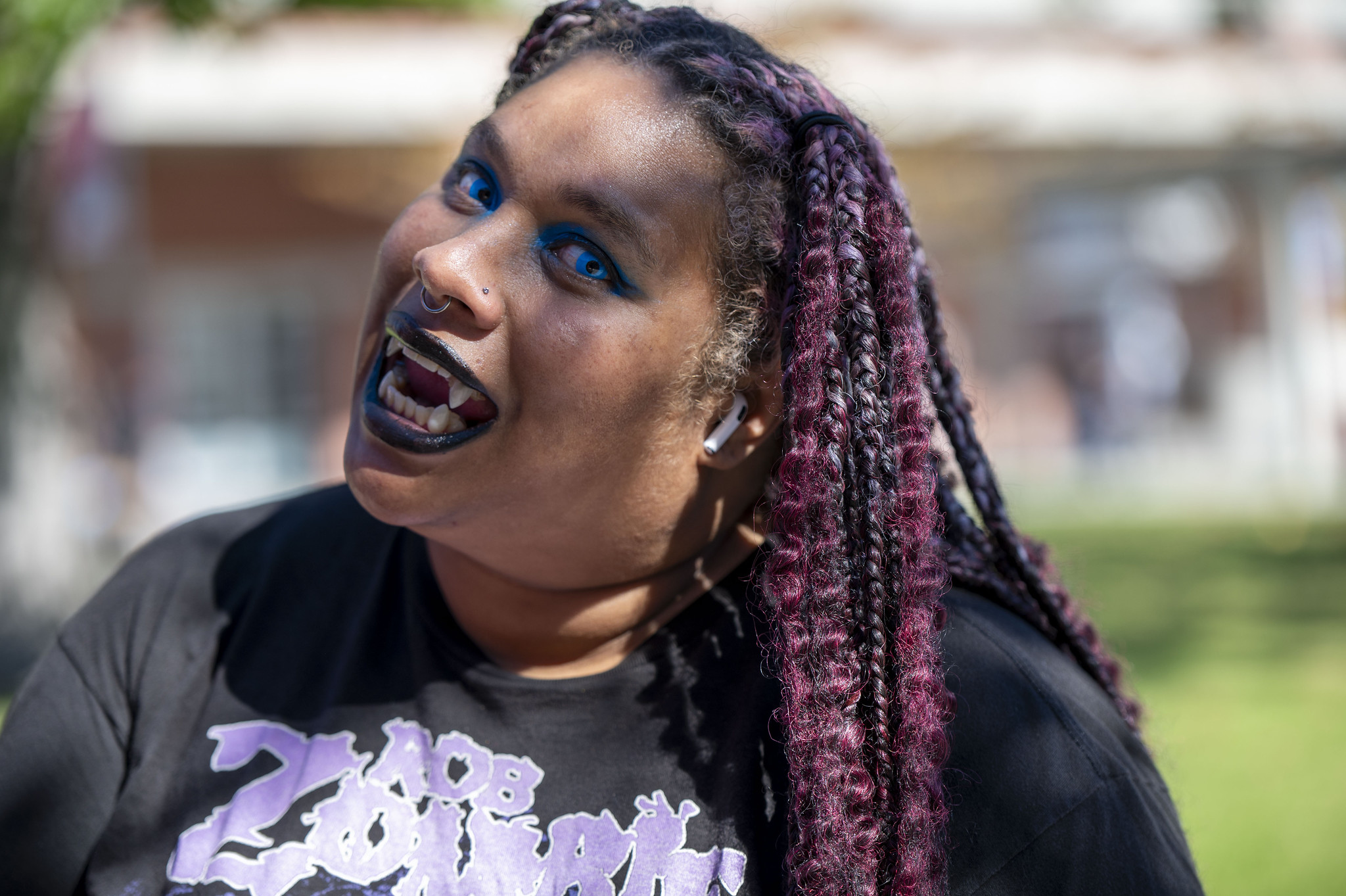 
A woman wearing vampire teeth.
