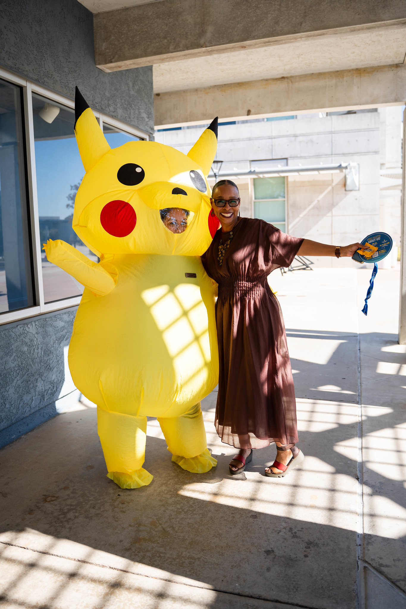 
Mesa College President Ashanti Hands with a giant yellow Picachu.
