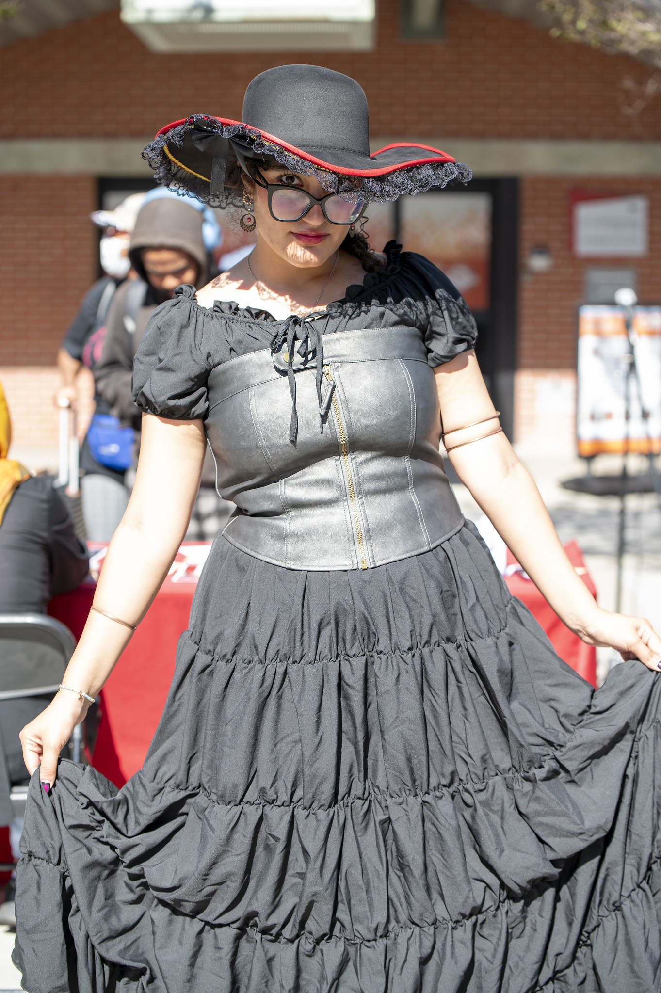 
A woman in a black dress and black hat.
