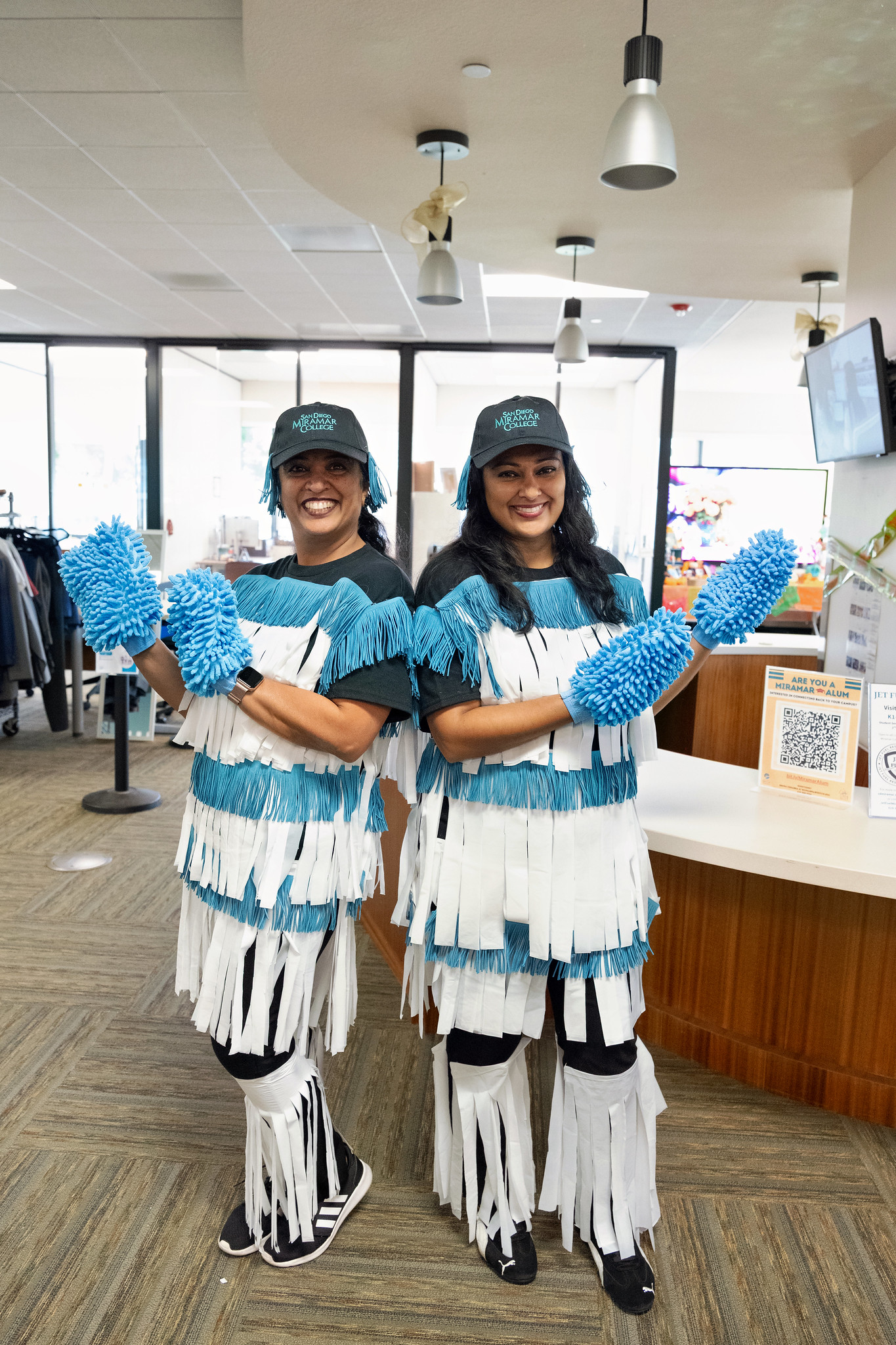 
Two women in teal and white dressed as car wash scrubbers.
