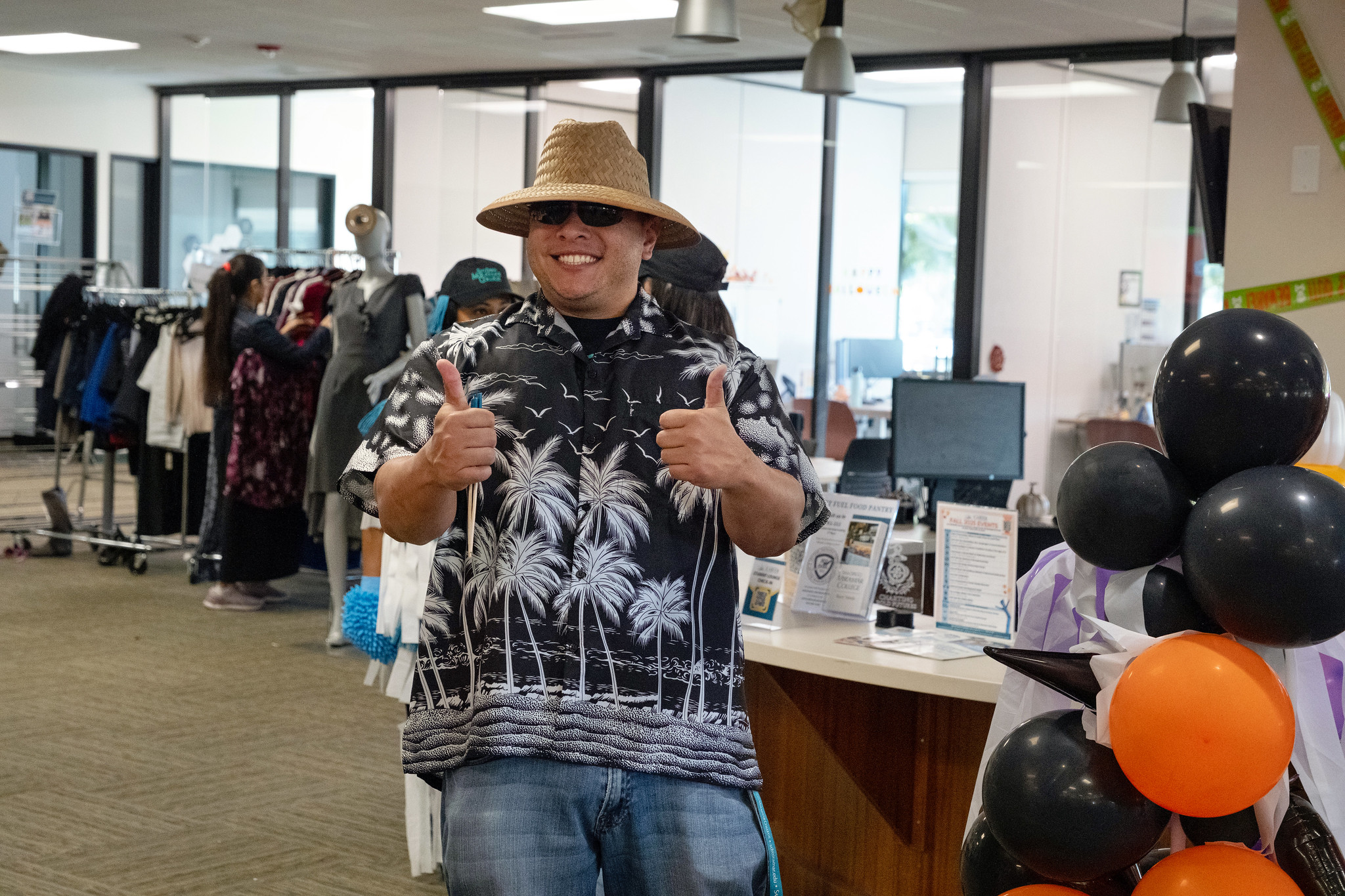 
A man wearing a Hawaiian shirt and a sun hat gives two thumbs up.&nbsp;
