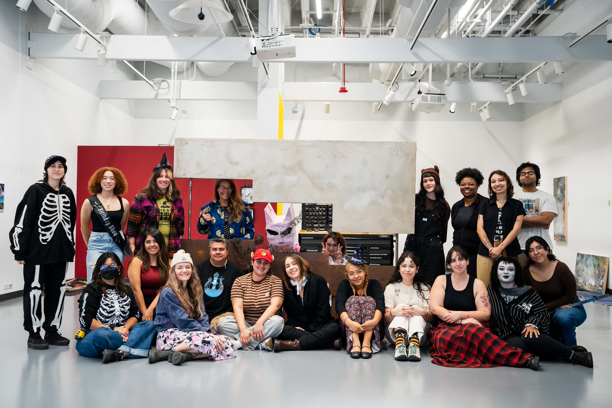 
20 people in various Halloween costumes at City College.
