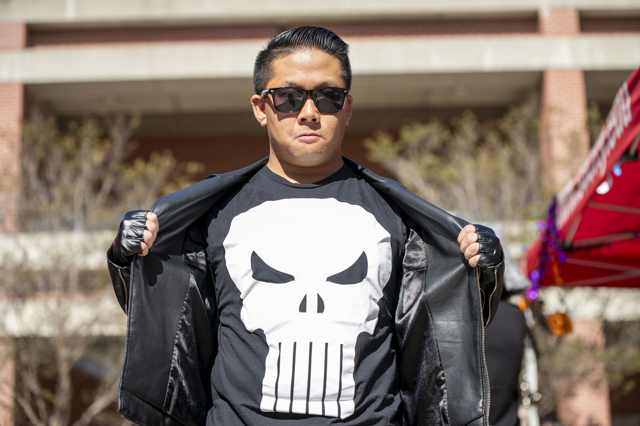 
A man opens up his black leather jacket to show a skeleton face on a black t-shirt.&nbsp;
