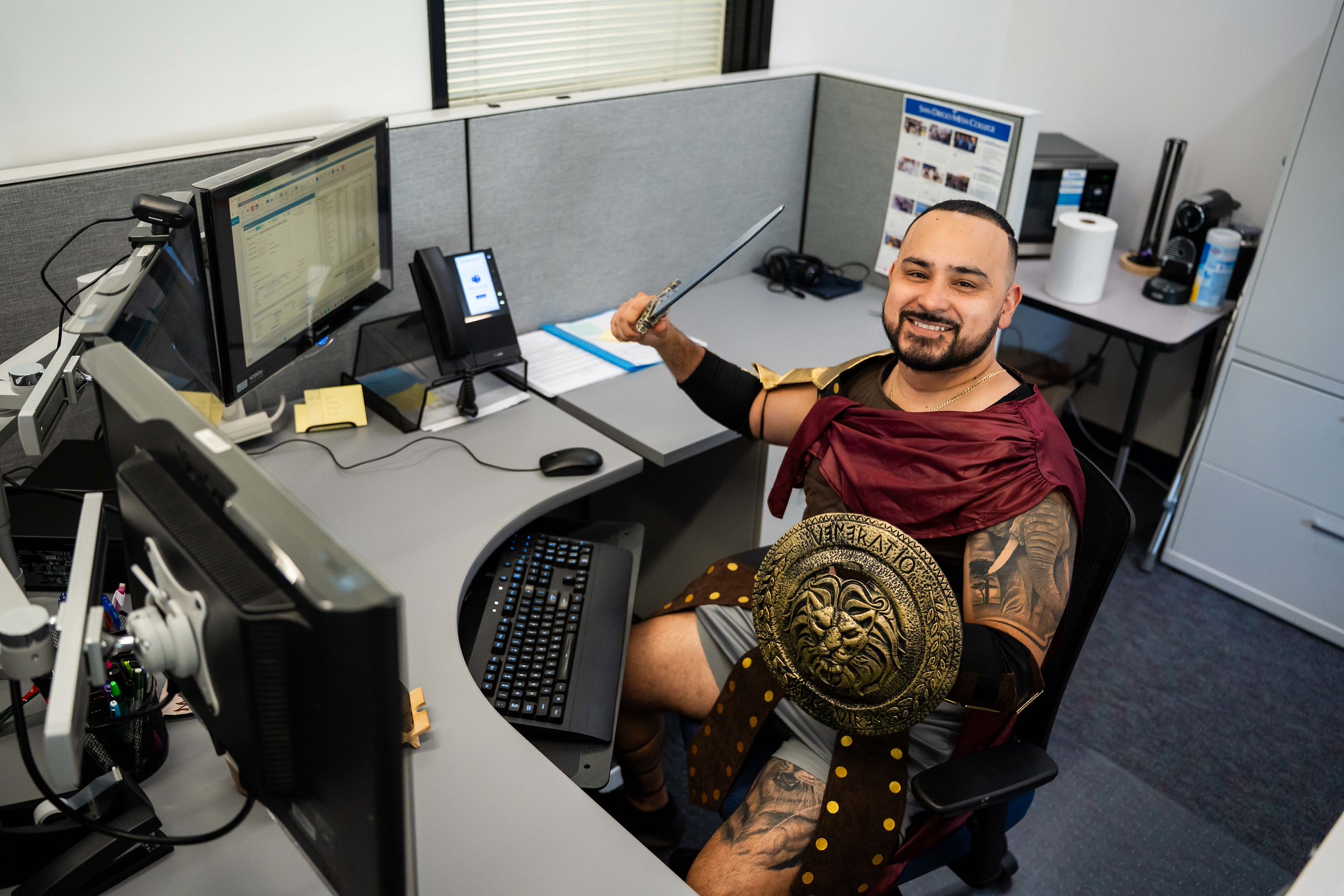 
A man in a gladiator costume holds a spear and a shield.

