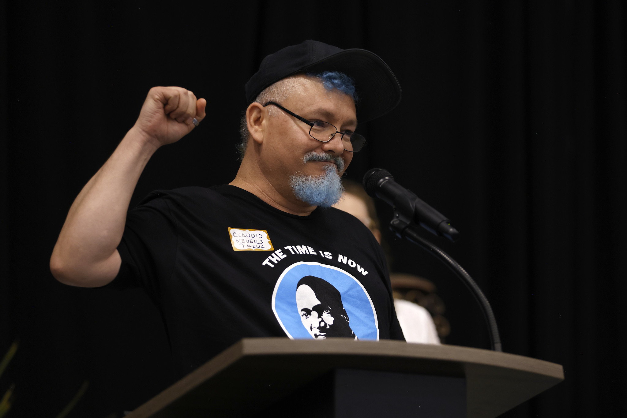 
A student cheers as he speaks at a podium.

