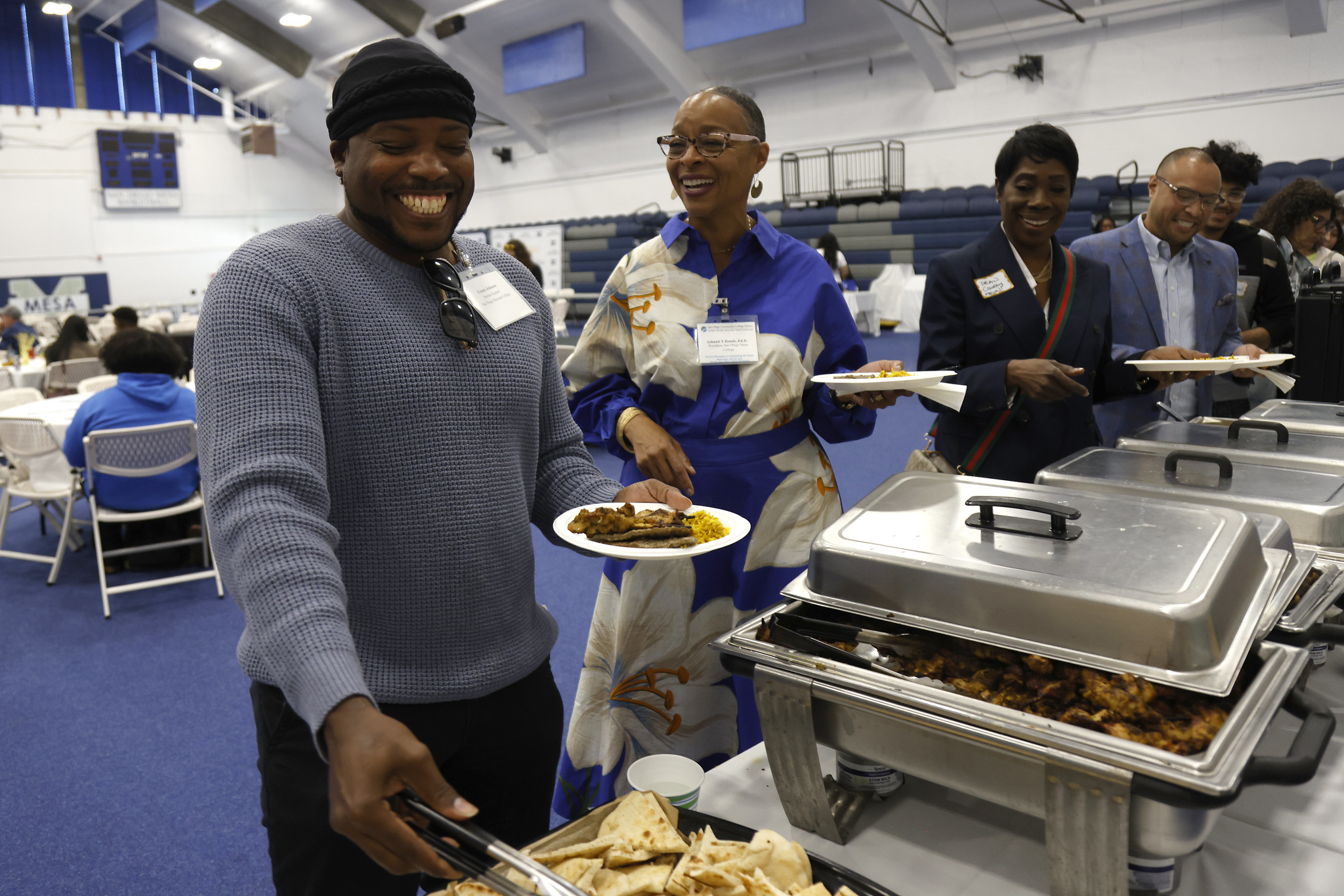 
Four people line up at the food buffet.
