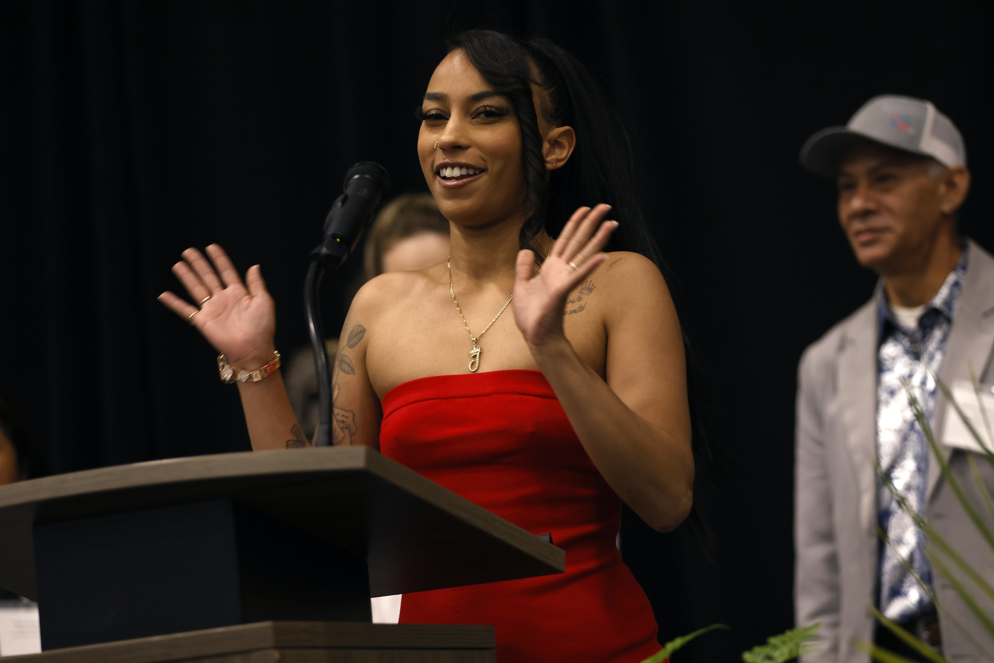 
A student in a red dress speaking at the podium.

