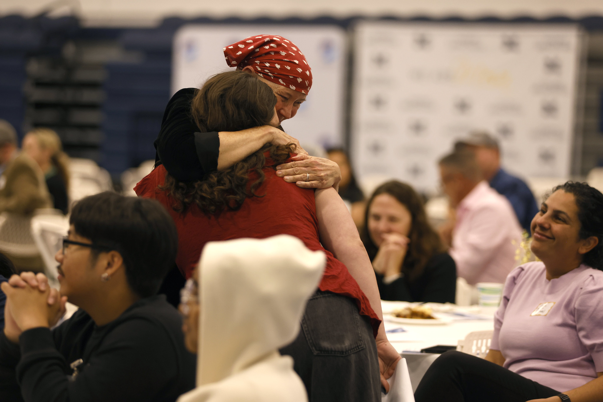 
A teacher hugs a student at the luncheon.
