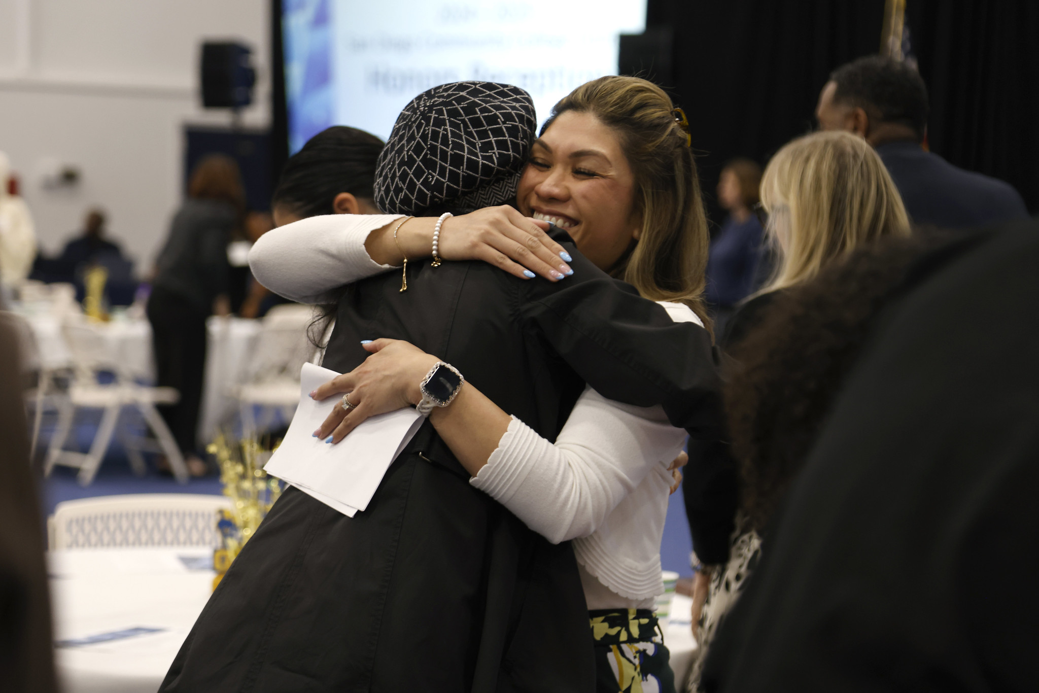 
A student and a teacher hug at the luncheon.
