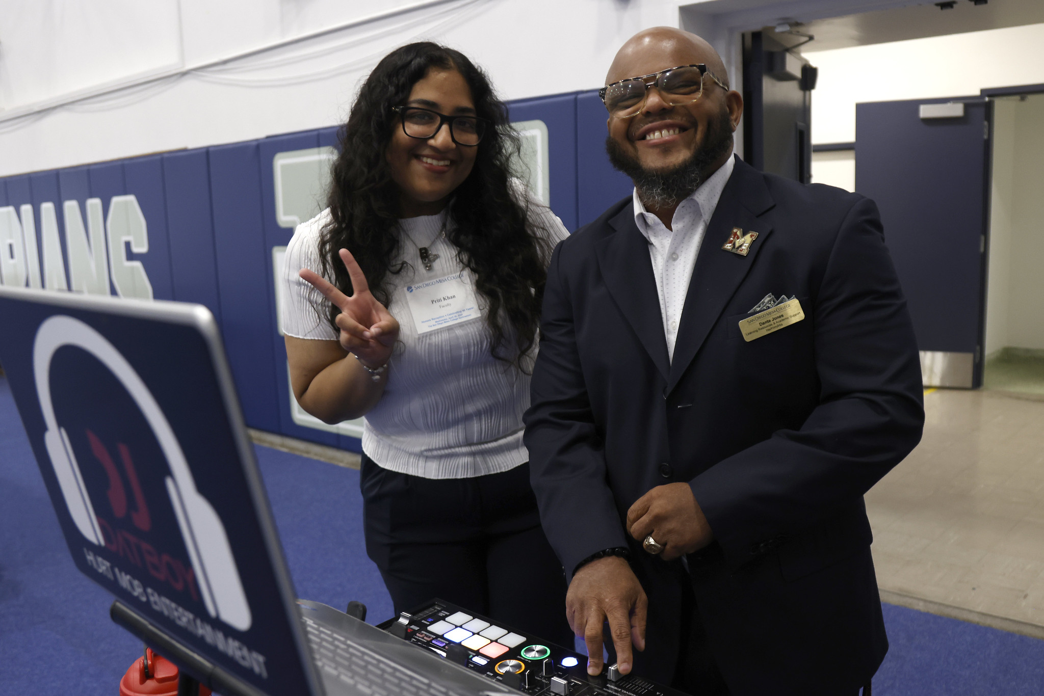
An honor student with the DJ of the event holds up a peace sign.
