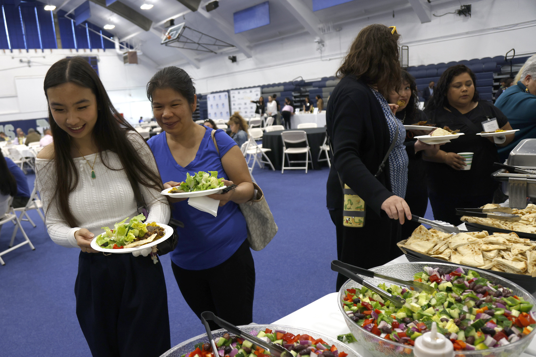 
Three people line up for the buffet.
