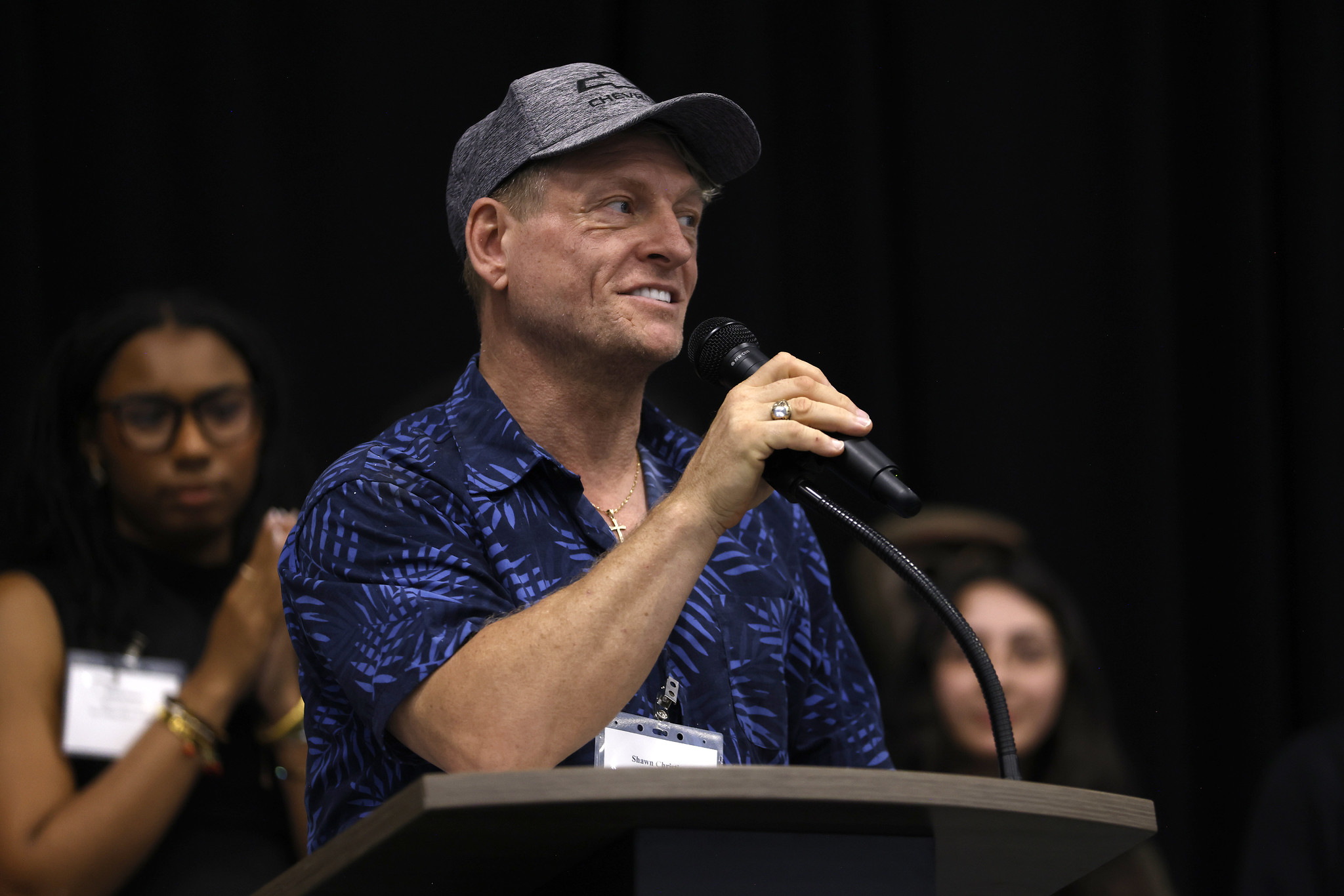 
A student in a blue shirts and a baseball cap speaks at the luncheon.

