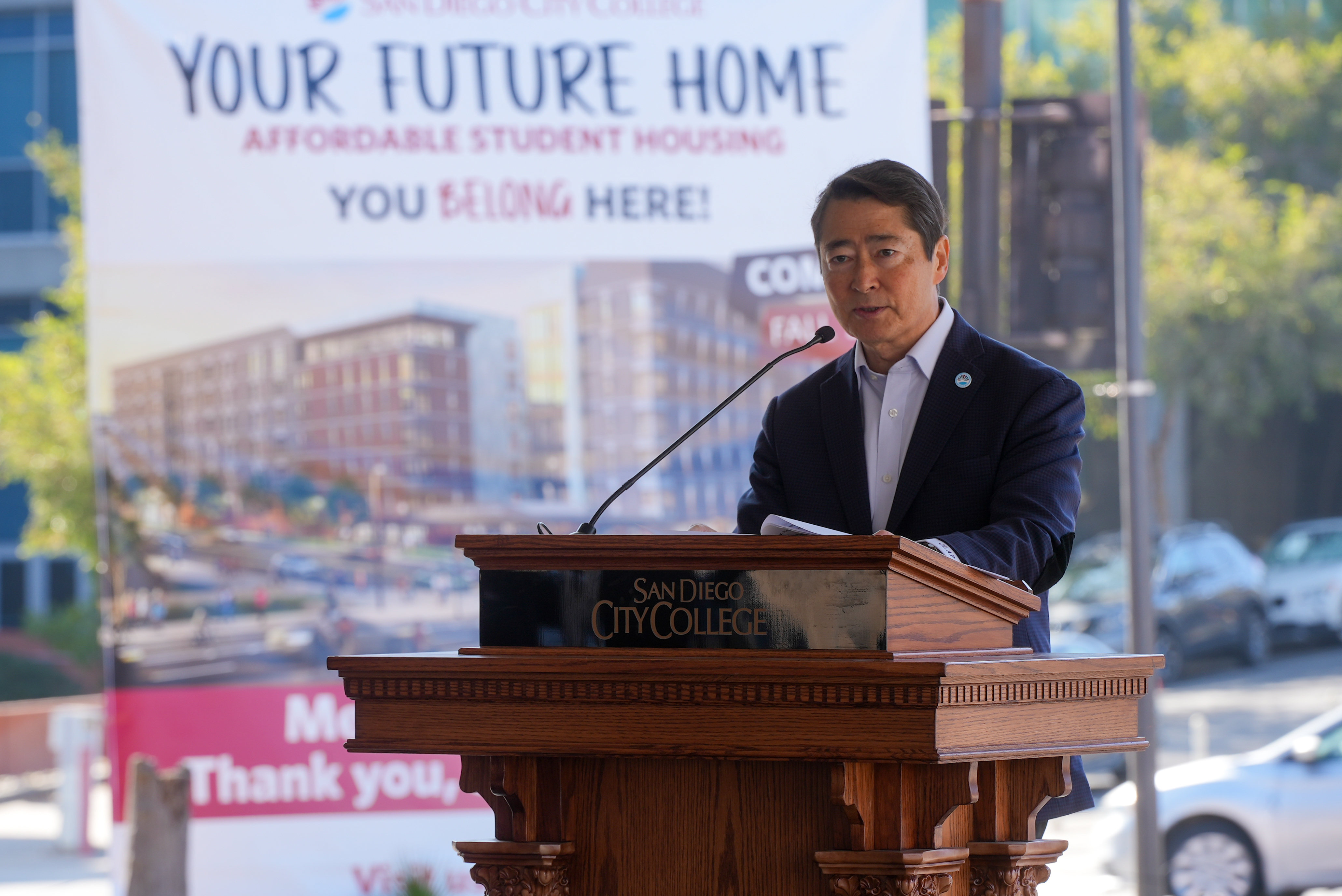 
Vice Chancellor of Operations, Enterprise Services and Facilities Joel Peterson at a podium speaking to the crowd.
