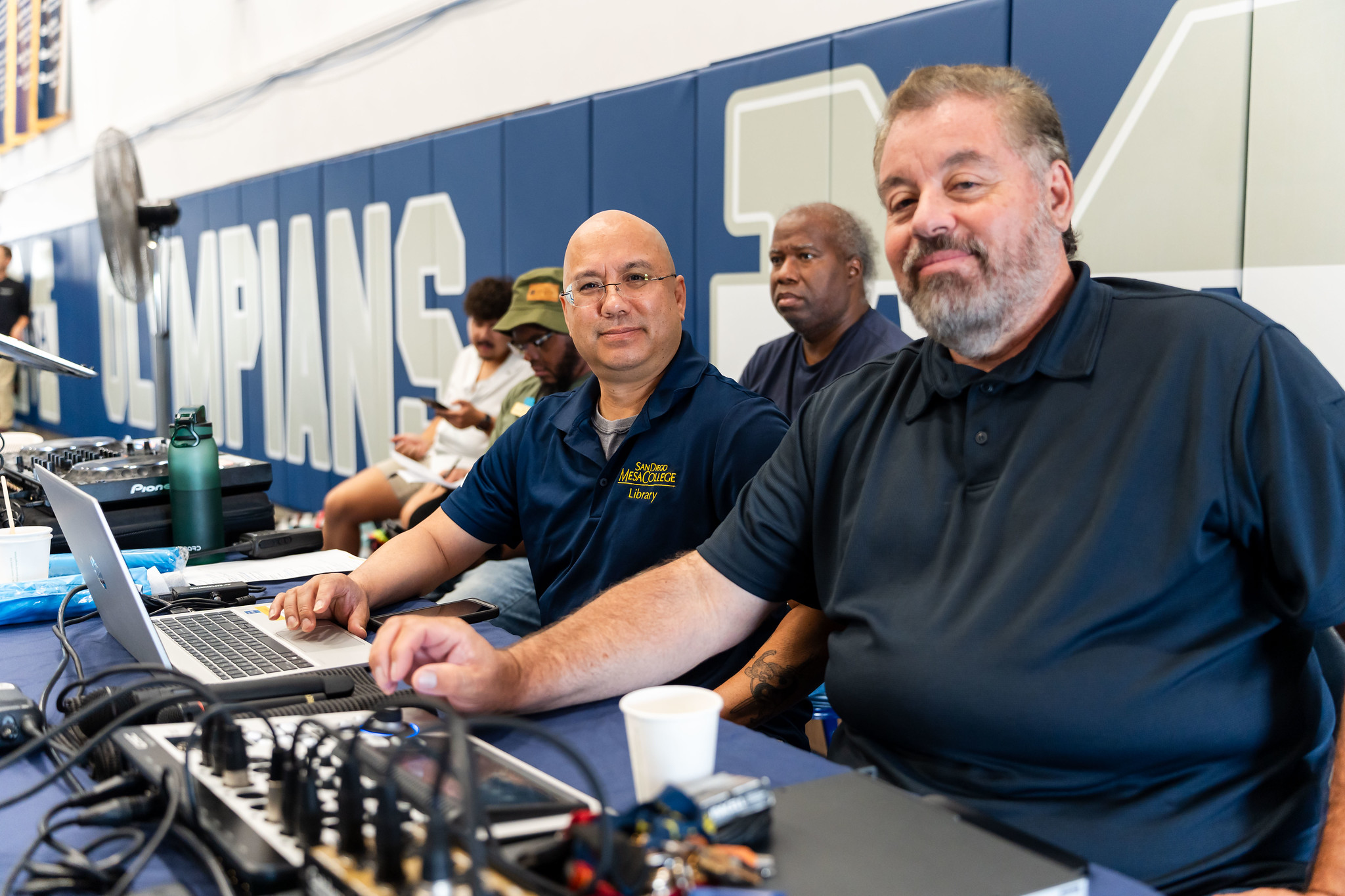 
Two men sitting at a table managing the Audio and Video for the event.
