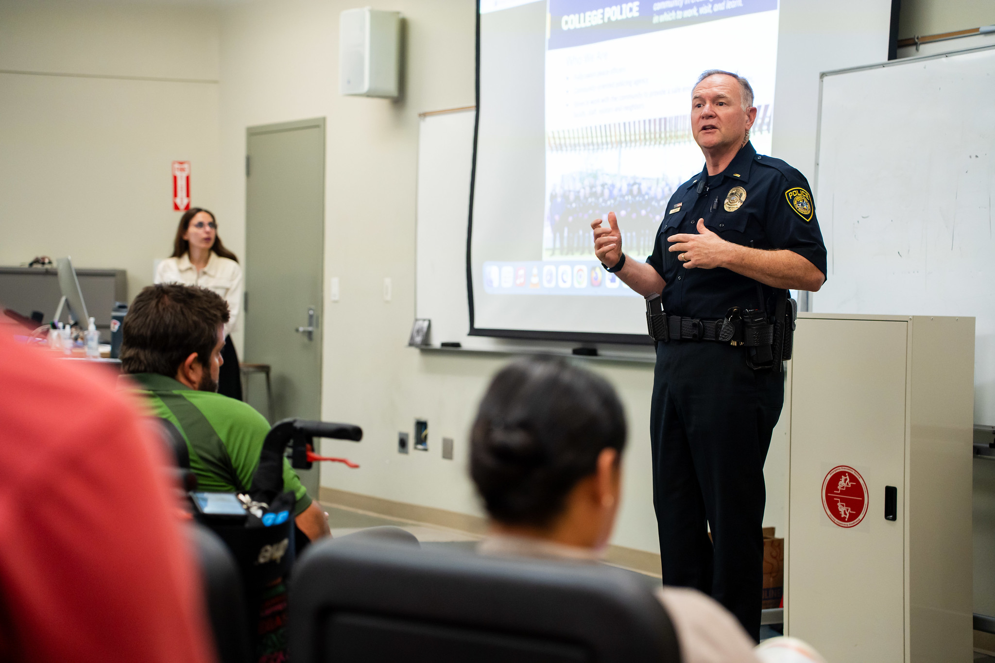 
College Police Officer Lt. Ken Nelson addresses a classroom of people.
