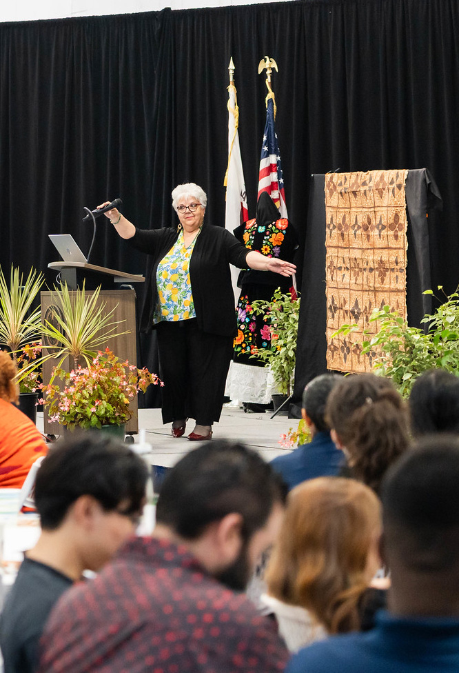 
Dr. Isabel O'Connor on stage speaking to the audience.
