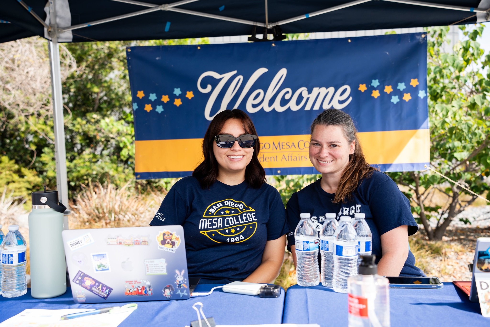 
Two women working at a welcome booth.
