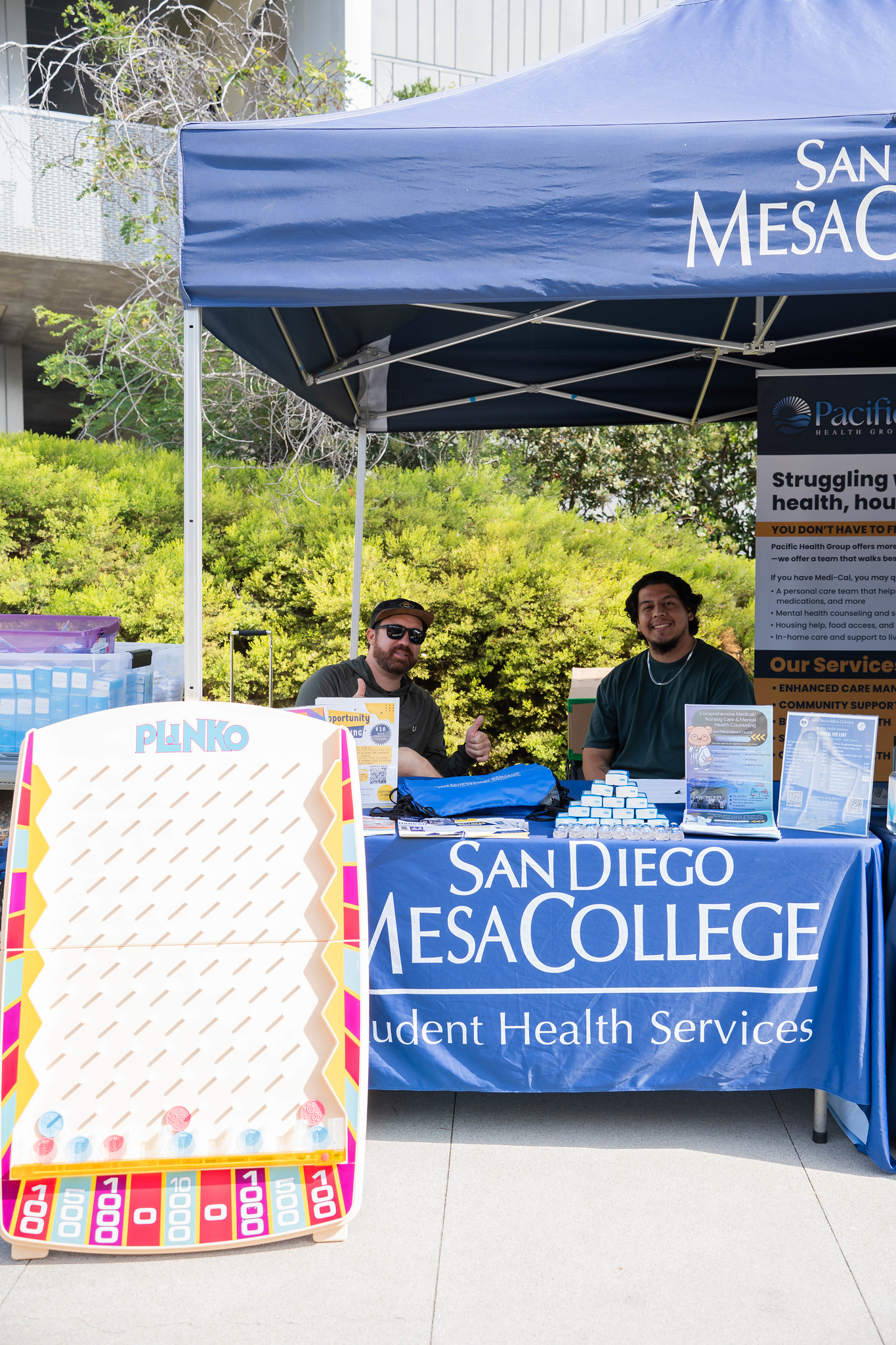 
Two people working the Student Health Services booth. A plinko board is in front for students to play for prizes.
