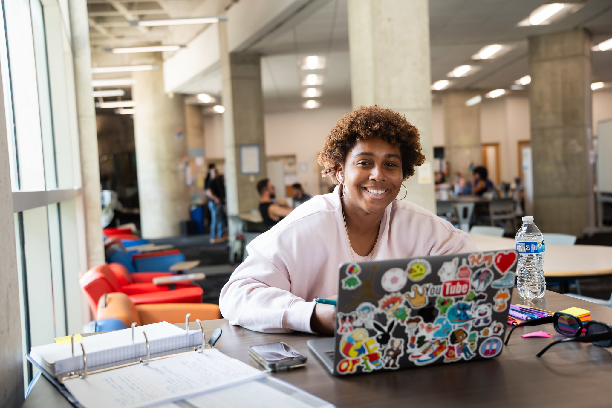 
A student at a table working on a laptop.
